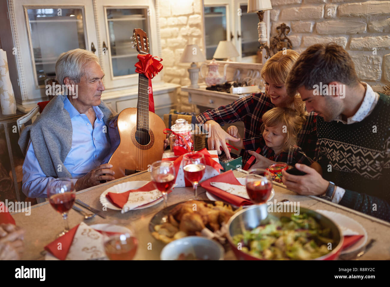 La famiglia felice con la canzone celebrare la festa di Natale Foto Stock