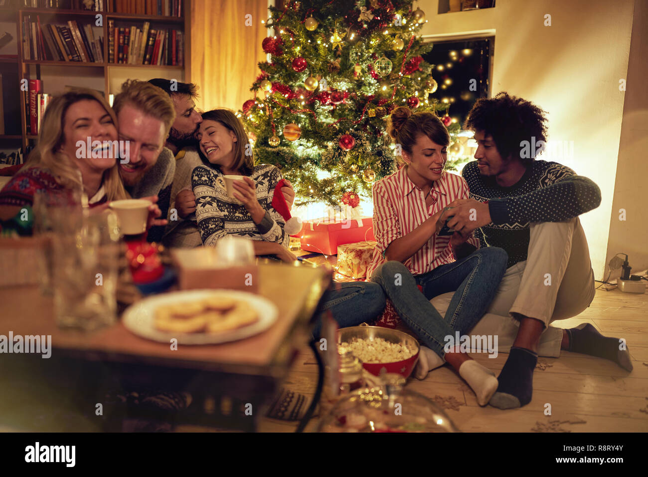 Allegra e felice amici per celebrare il Natale a casa Foto Stock