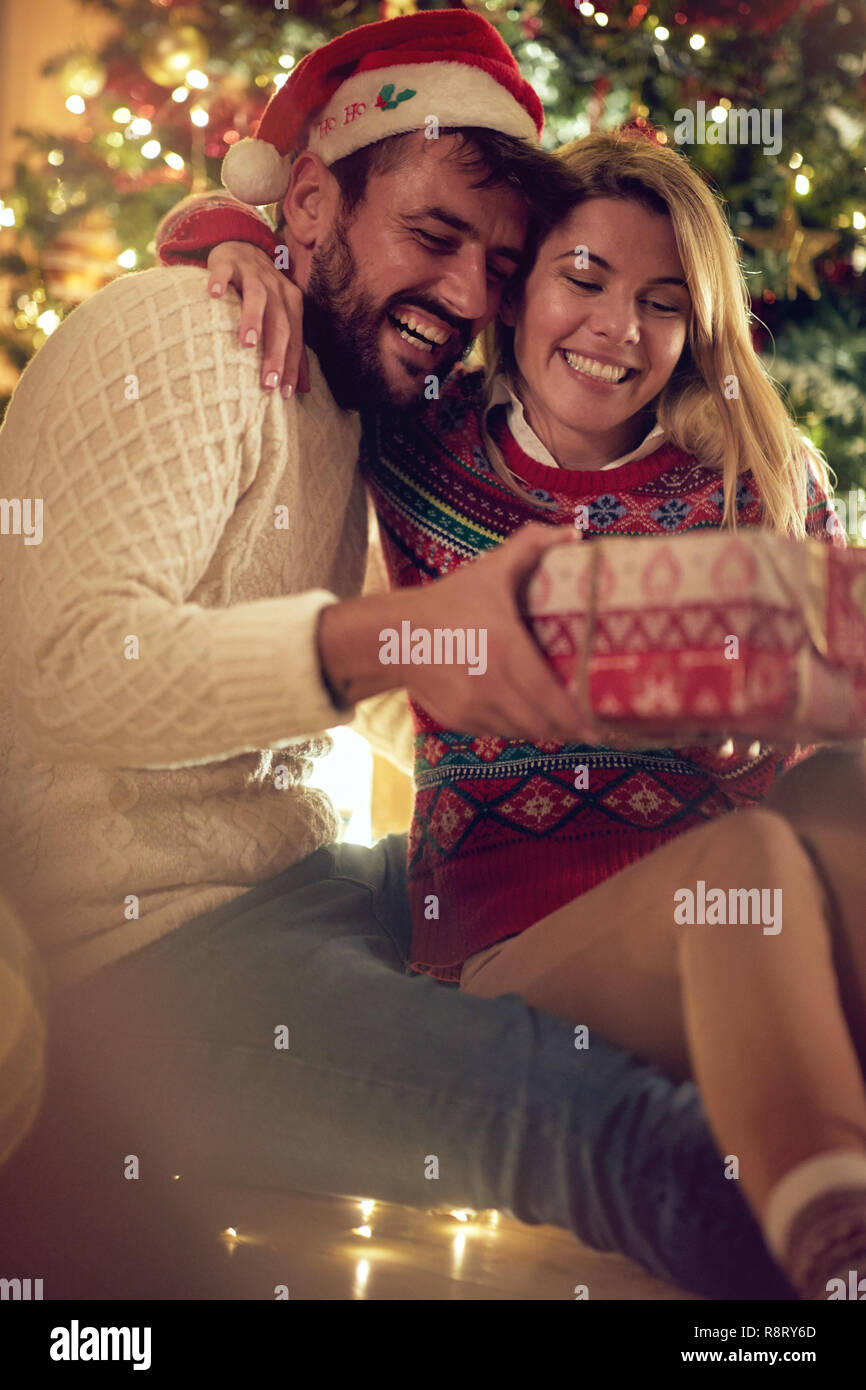Tradizione di natale - Coppia sorridente con dono godendo insieme alla vigilia di Natale Foto Stock