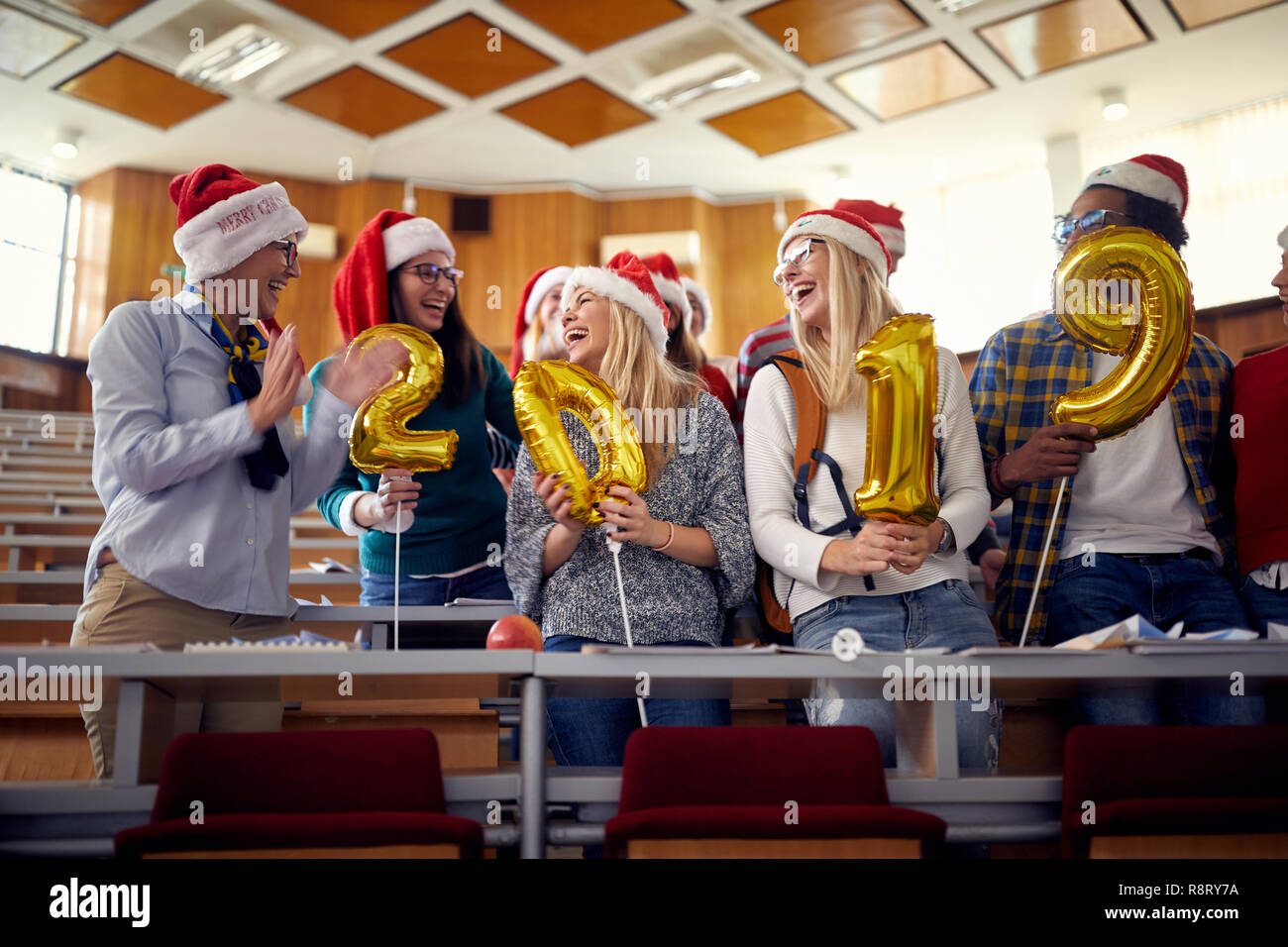 Gruppo di colleghi felice in Santa hat divertendosi al nuovo anno celebrazione sulla university Foto Stock