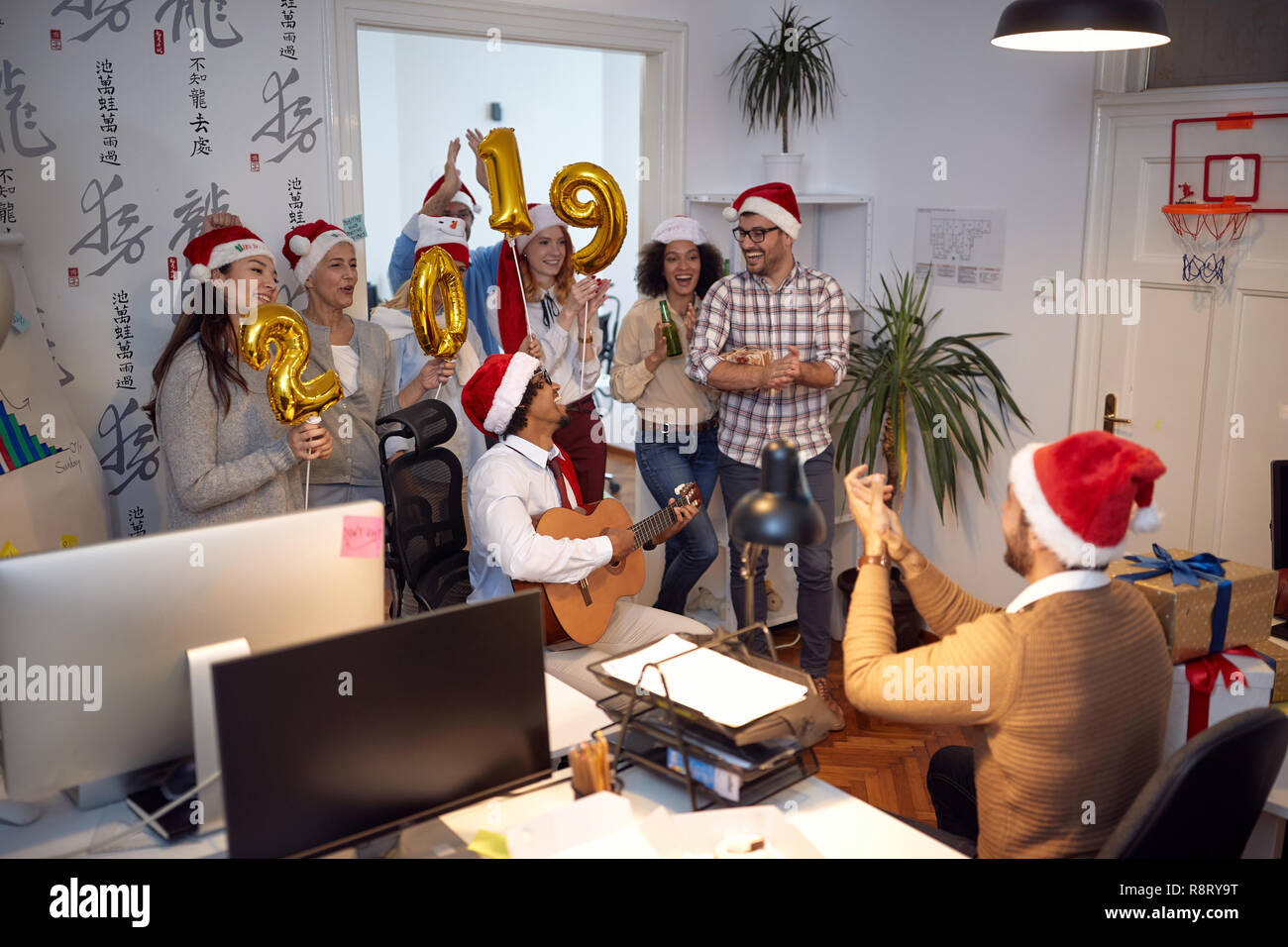 Sorridente lavoratori aziendali hanno divertimento e balli in Santa hat alla festa di Natale in ufficio Foto Stock