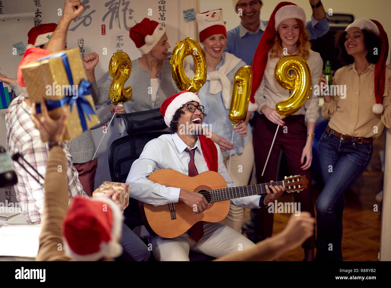 La gente di affari hanno divertimento e balli in Santa hat a Xmas Party in ufficio Foto Stock