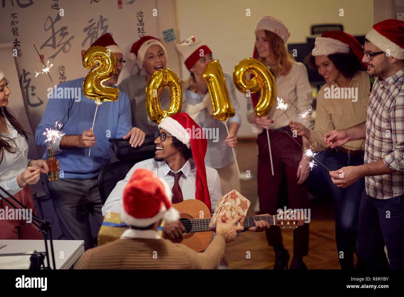 Sorridente business group divertendosi al nuovo anno celebrazione durante il lavoro Foto Stock