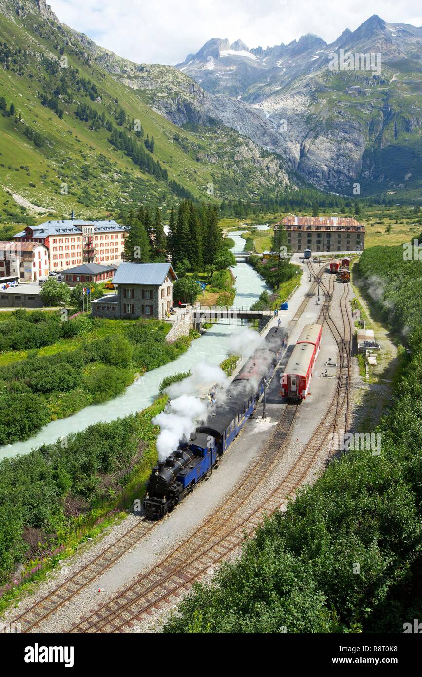 La Svizzera nel canton Vallese, Gletsch, il Rodano, la stazione ferroviaria e il treno a vapore, l'Hotel Glacier du Rhône e il Blue House in background Foto Stock