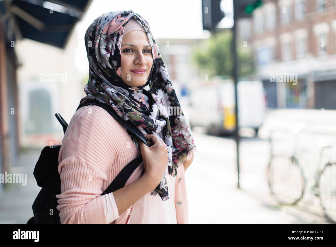 Ritratto di donna fiducioso in floral hijab sul marciapiede urbano Foto Stock