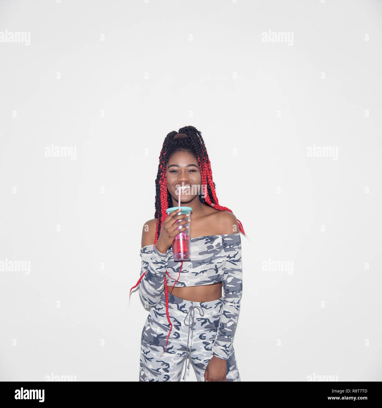 Ritratto fiducioso giovane donna in Abbigliamento camouflage di bere succo di frutta Foto Stock