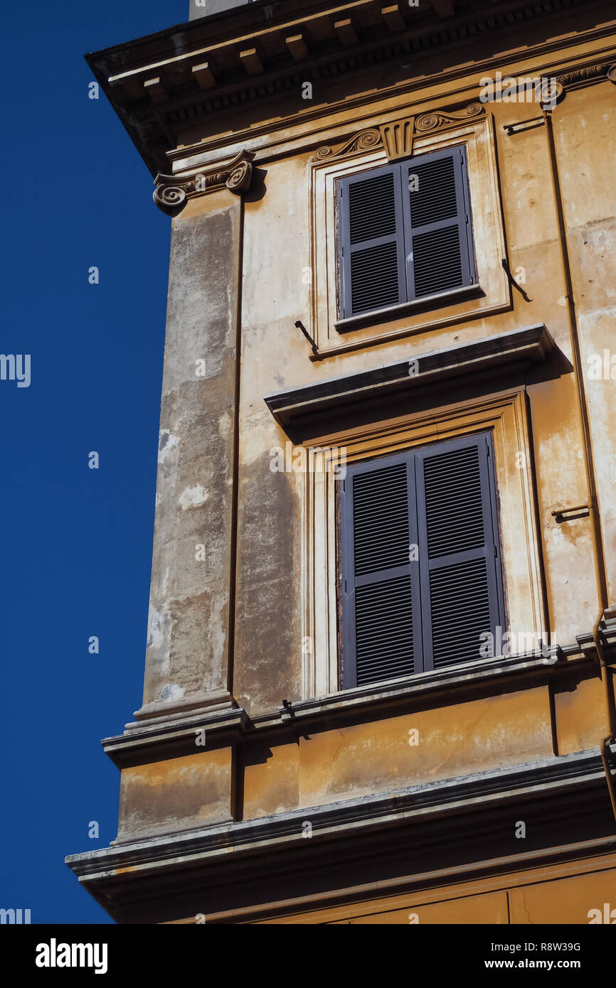 Angolo di un edificio italiano con intonaco giallo Foto Stock
