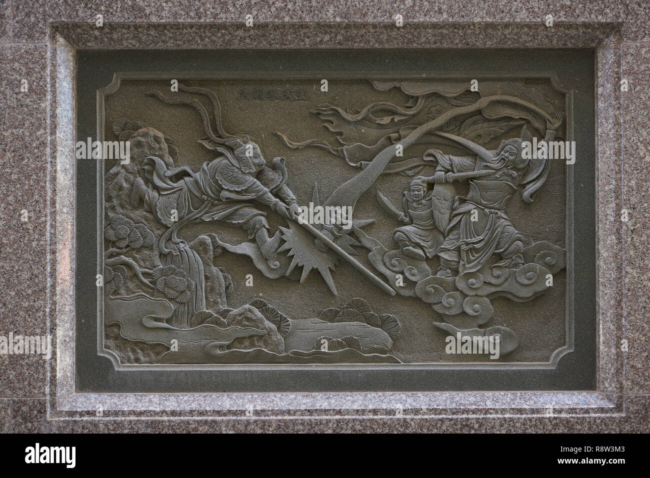 Dettaglio della pietra che intaglia nel retro del Kuang Im Cappella, vicino al Fiume Kwai, Kanchanaburi, Thailandia. L'illustrazione raffigura Sun Wukong, o re delle scimmie, lotta Foto Stock