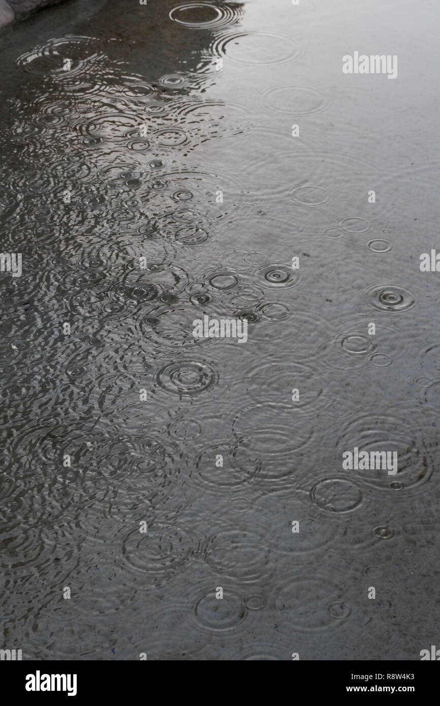 Pioggia increspa la superficie dell'acqua in una fontana di cemento, Roma, Italia Foto Stock