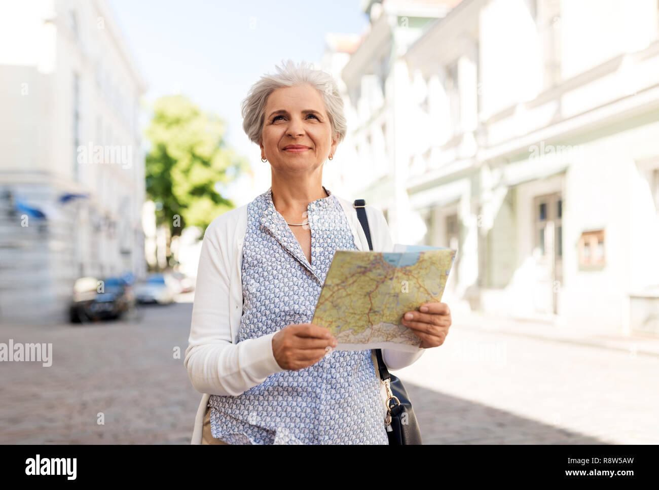 Senior donna o turistico con mappa su una strada di città Foto Stock