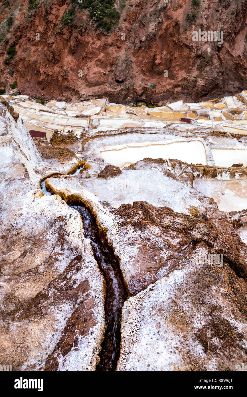 Ruscello d'acqua che scorre nelle piscine di sale a Maras (Salinas de Maras), Valle Sacra, Perù Foto Stock