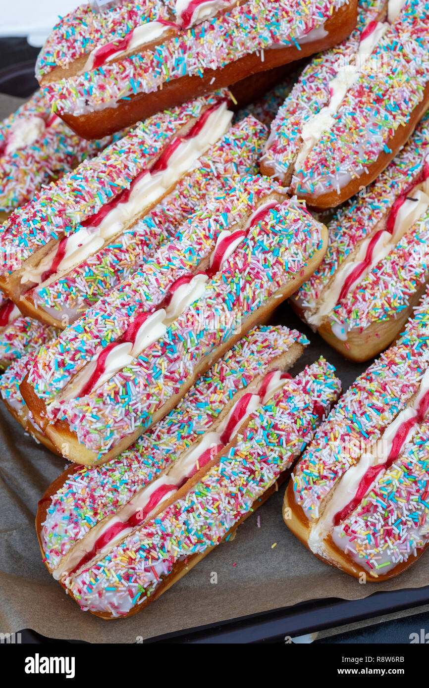 Cospargere split iced ciambelle con marmellata e crema su una fase di stallo a victorian mercatino di natale. Stratford Upon Avon, Warwickshire, Inghilterra Foto Stock