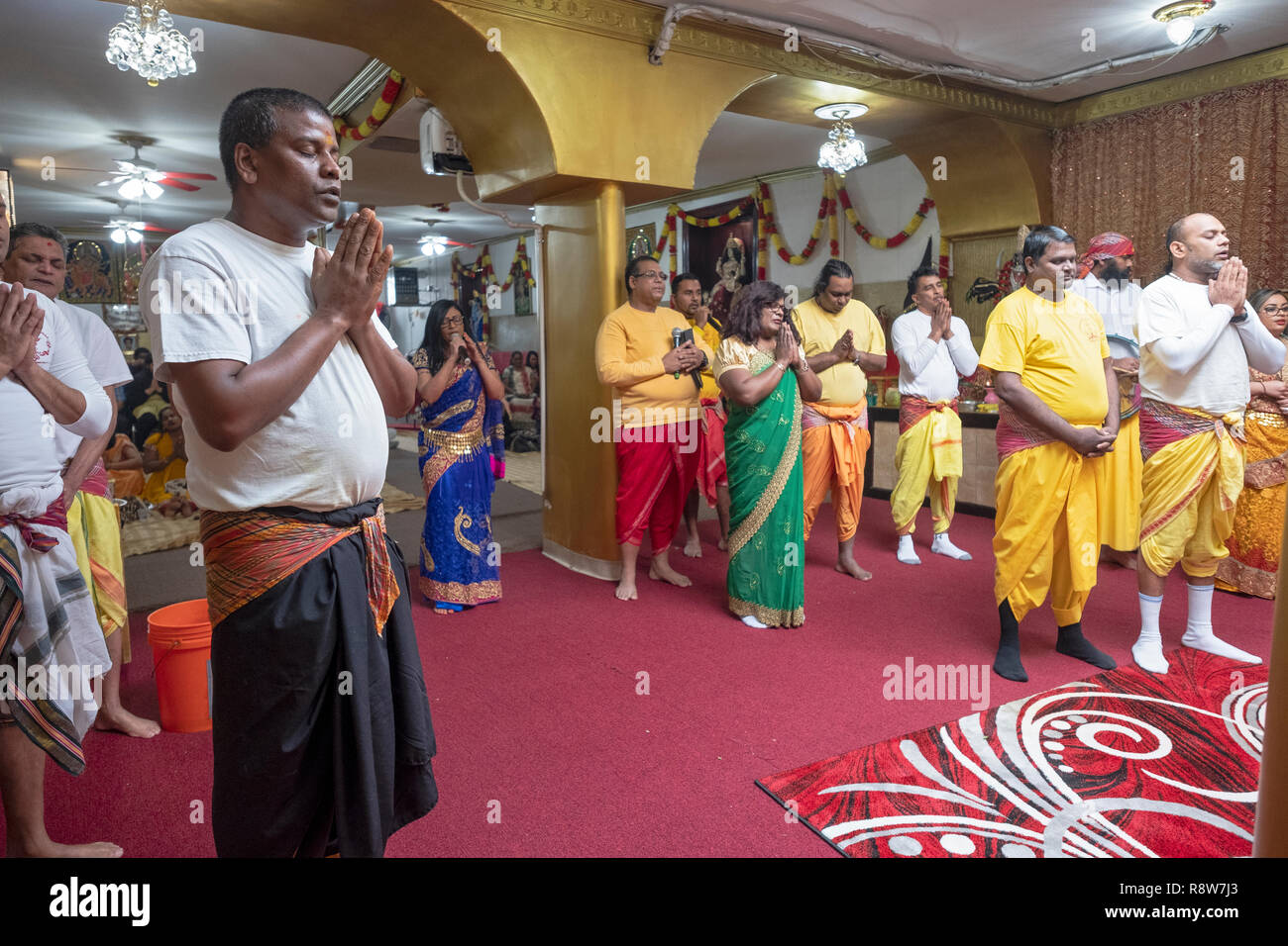 Un gruppo di Indù devoto di uomini e donne di preghiera e di meditazione a un tempio nel Queens, a New York City. Foto Stock