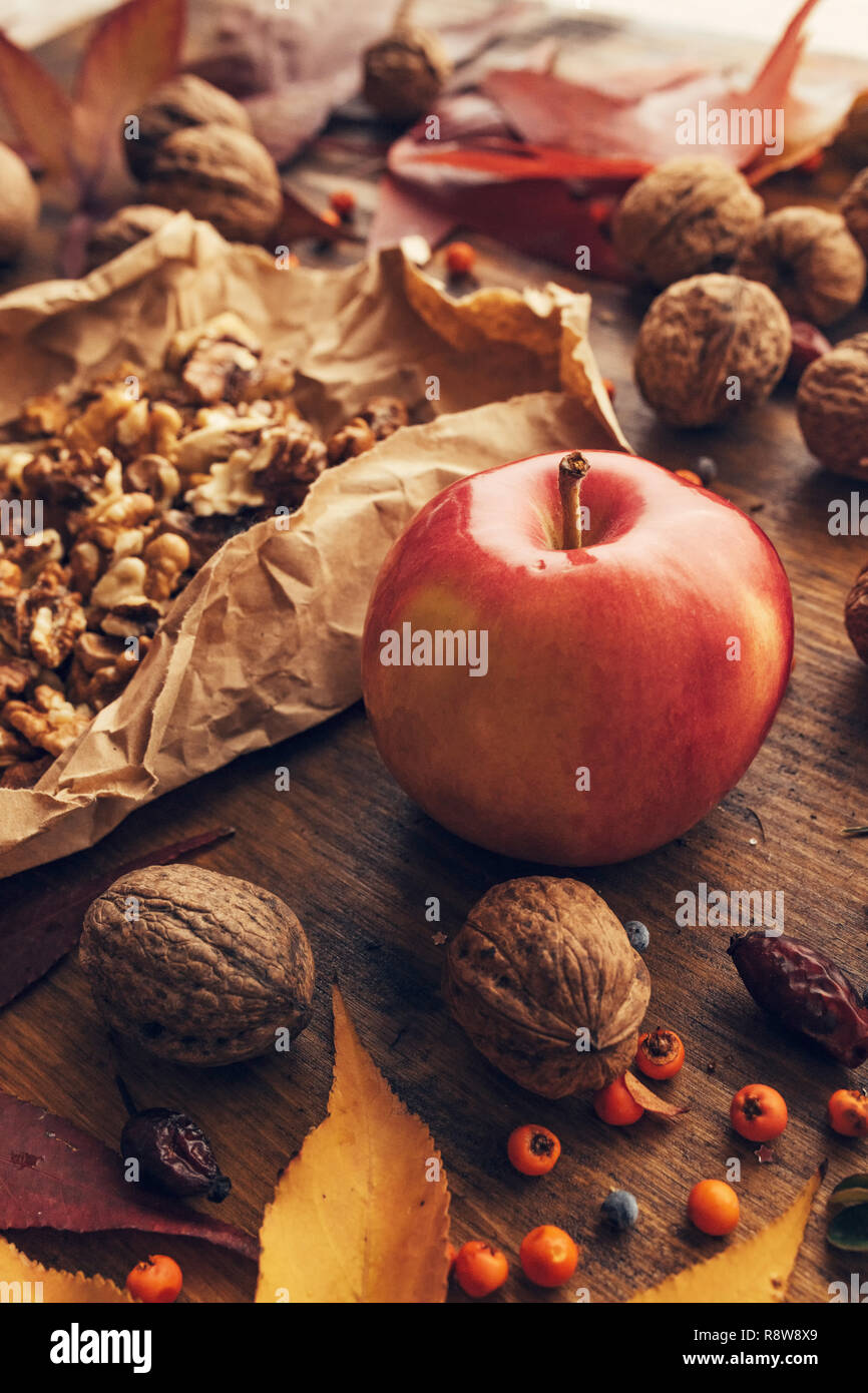 Apple e noce, autunno abbondanza - Sano frutta organica sul tavolo in legno decorata con colorate foglie di acero e bacche, close up Foto Stock