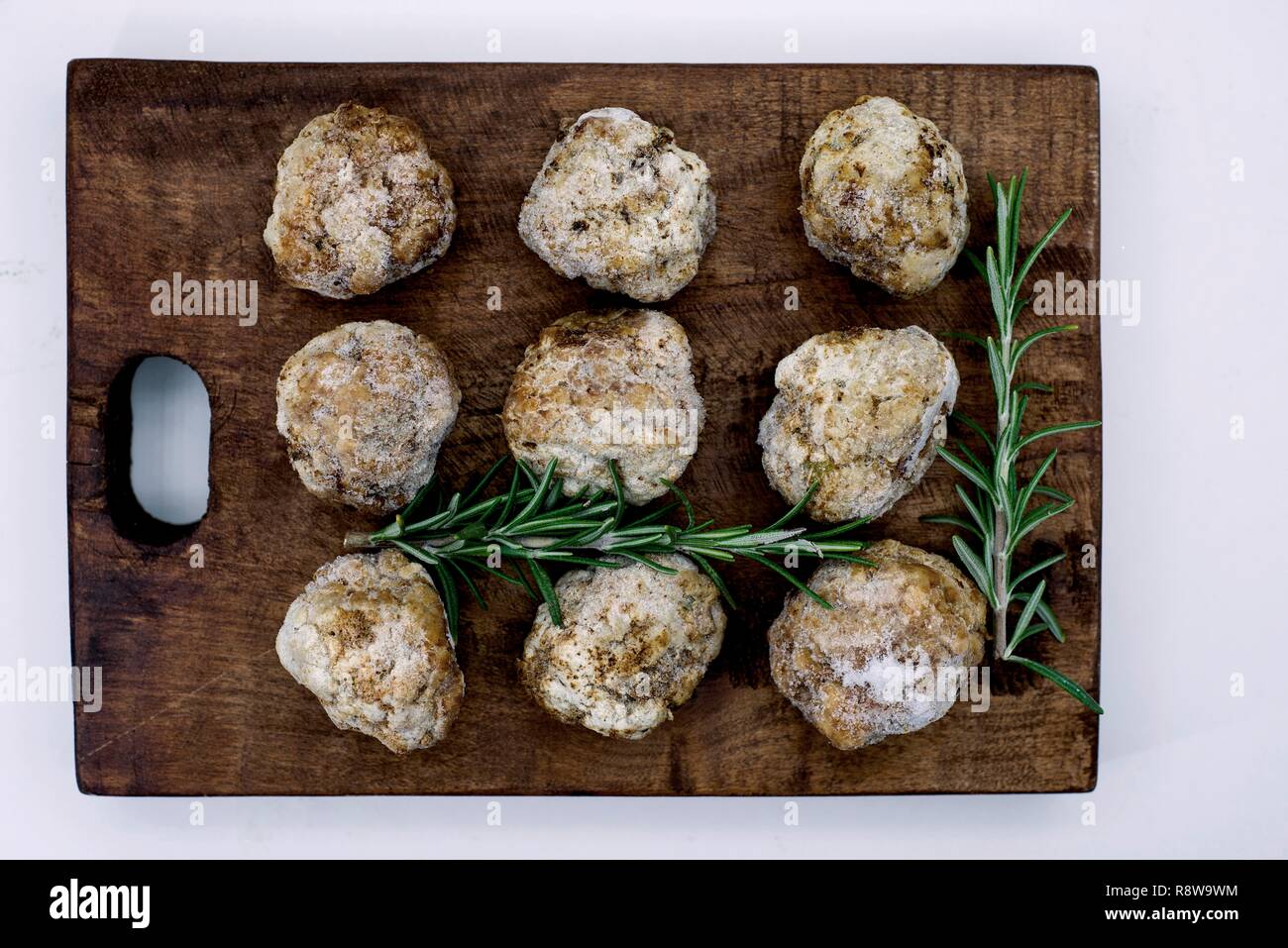 Con le polpette fritte non gelate su una scheda di cucina con rametti di rosmarino Foto Stock