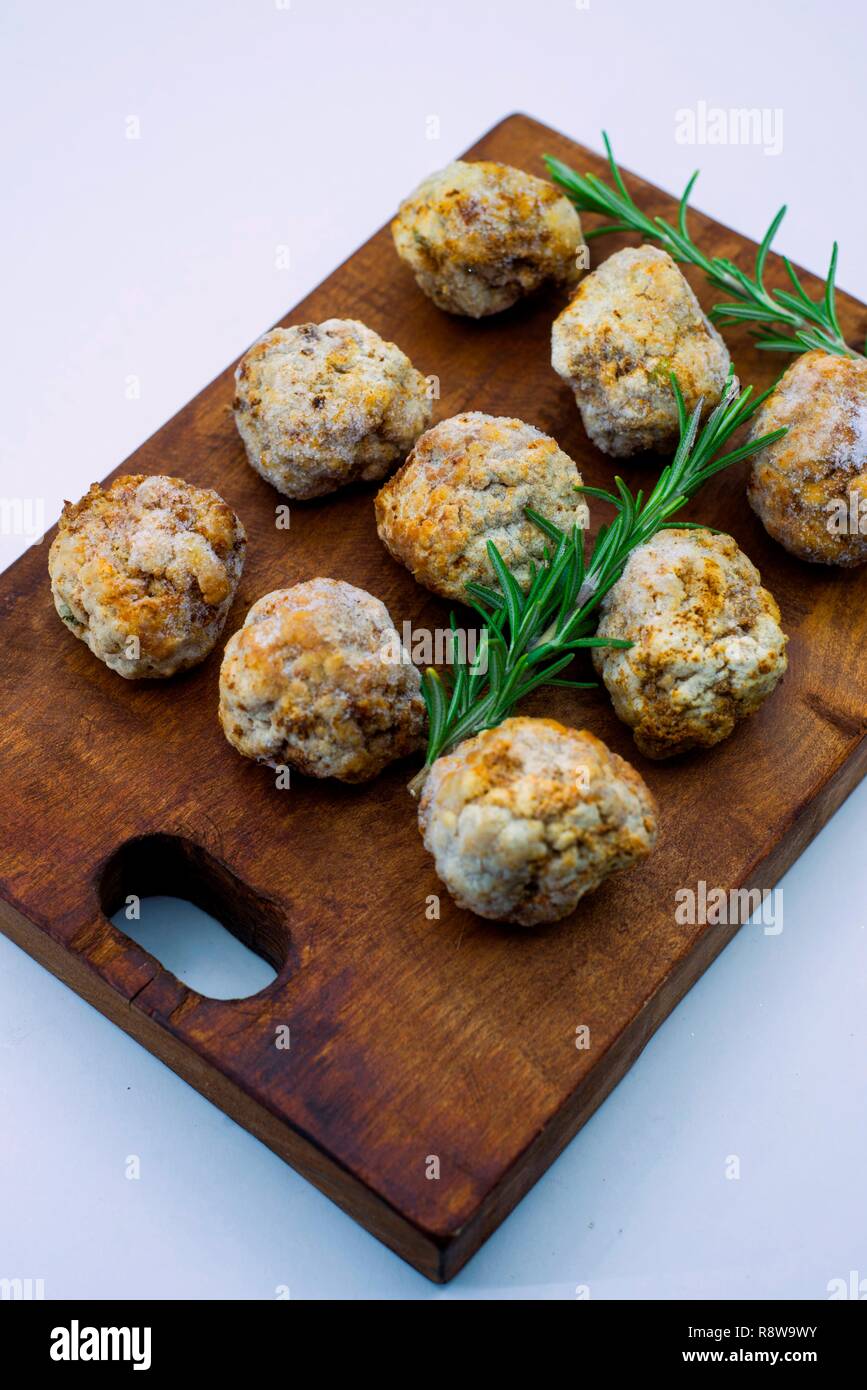 Con le polpette fritte non gelate su una scheda di cucina con rametti di rosmarino Foto Stock