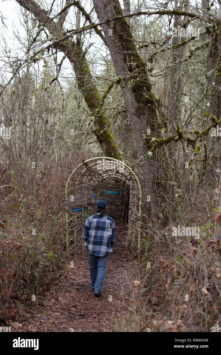 Un uomo a piedi attraverso le zone umide display a Mount Pisgah Arboretum di Eugene, Oregon, Stati Uniti d'America. Foto Stock