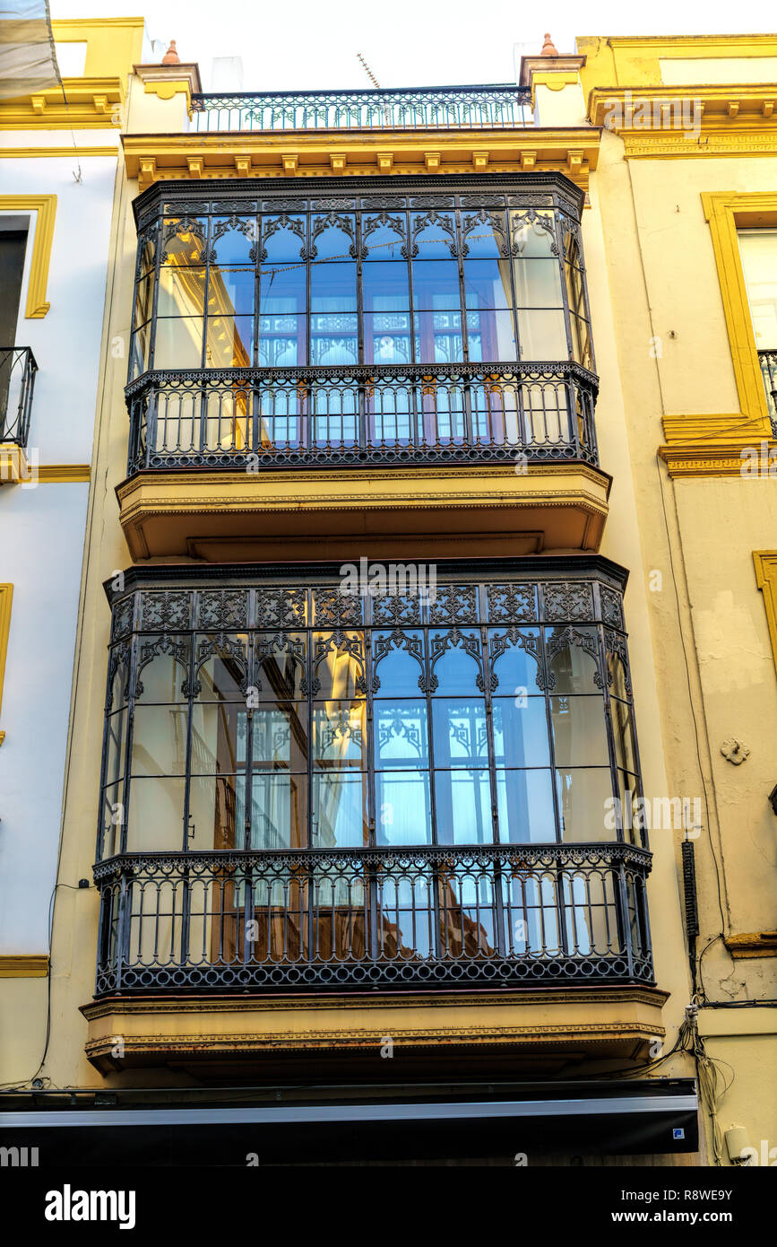 La parte esterna di uno storico edificio residenziale con balconi a Siviglia, in Andalusia, Spagna. Foto Stock