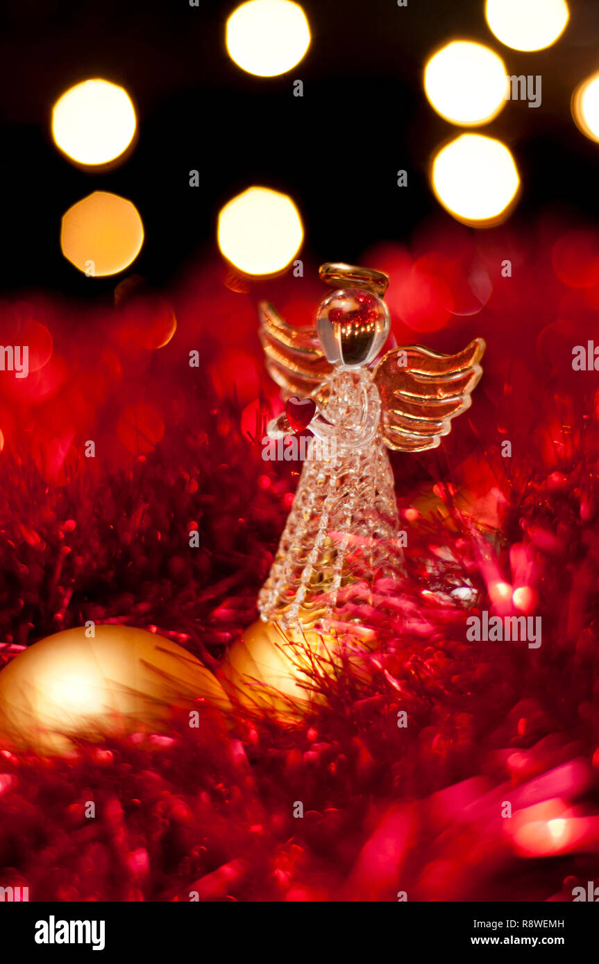 Christmas Angel decorazione nel mezzo di tinsel e baubles. Foto Stock