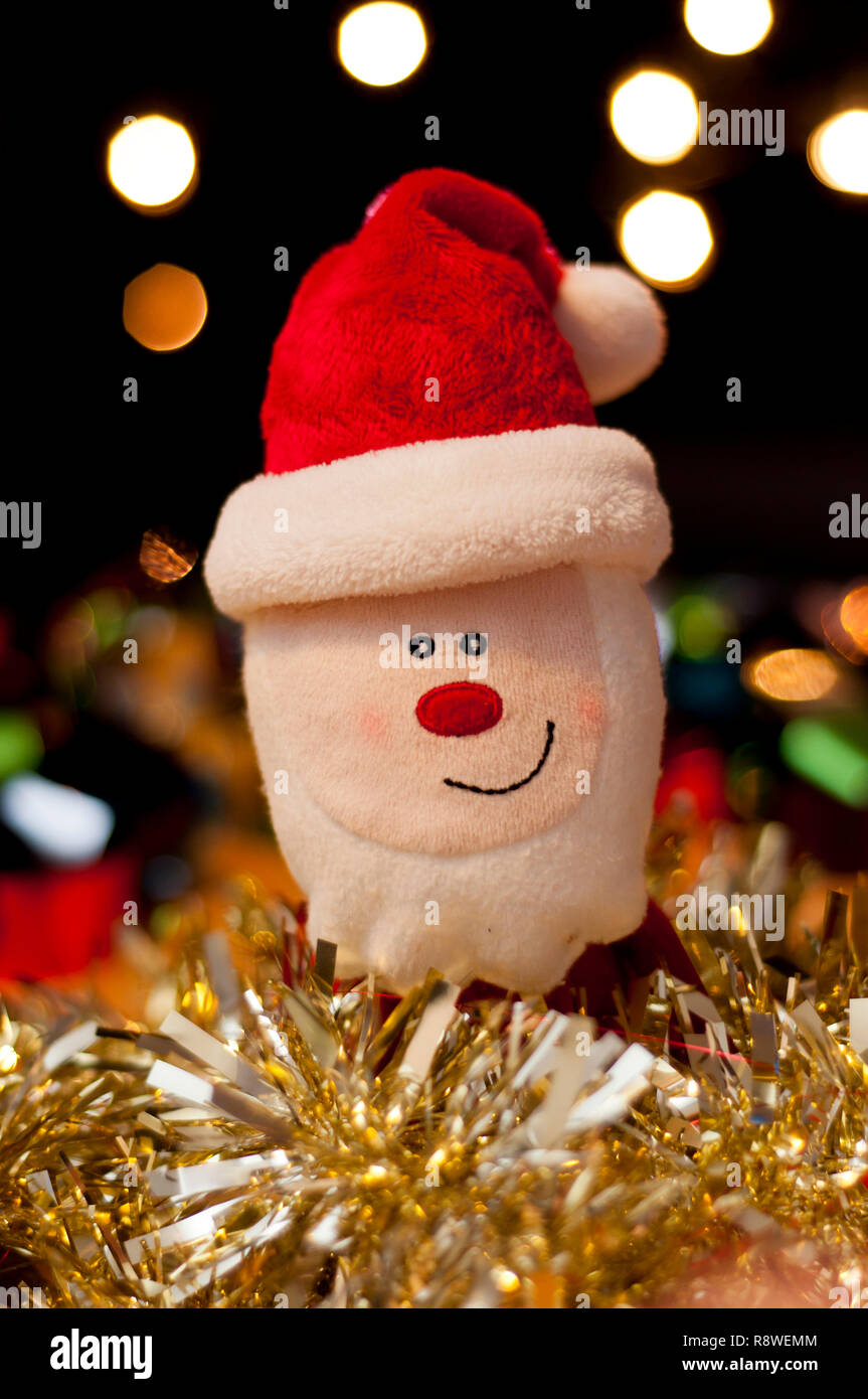 Babbo Natale Santa Claus toy nel mezzo di tinsel e baubles. Foto Stock