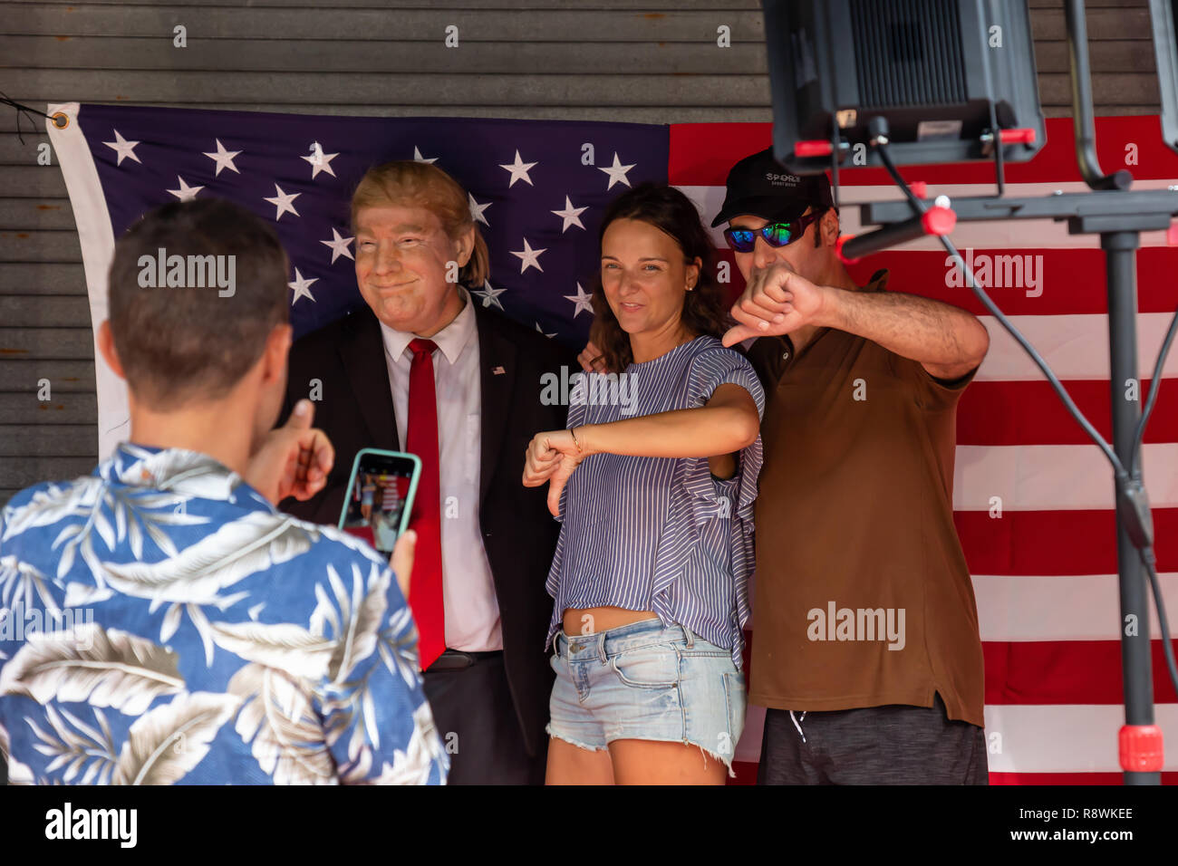 Key West, Florida, Stati Uniti - 2 Novembre 2018: persone che posano con Donald Trump Impersonator e mostrando il pollice verso il basso. Foto Stock