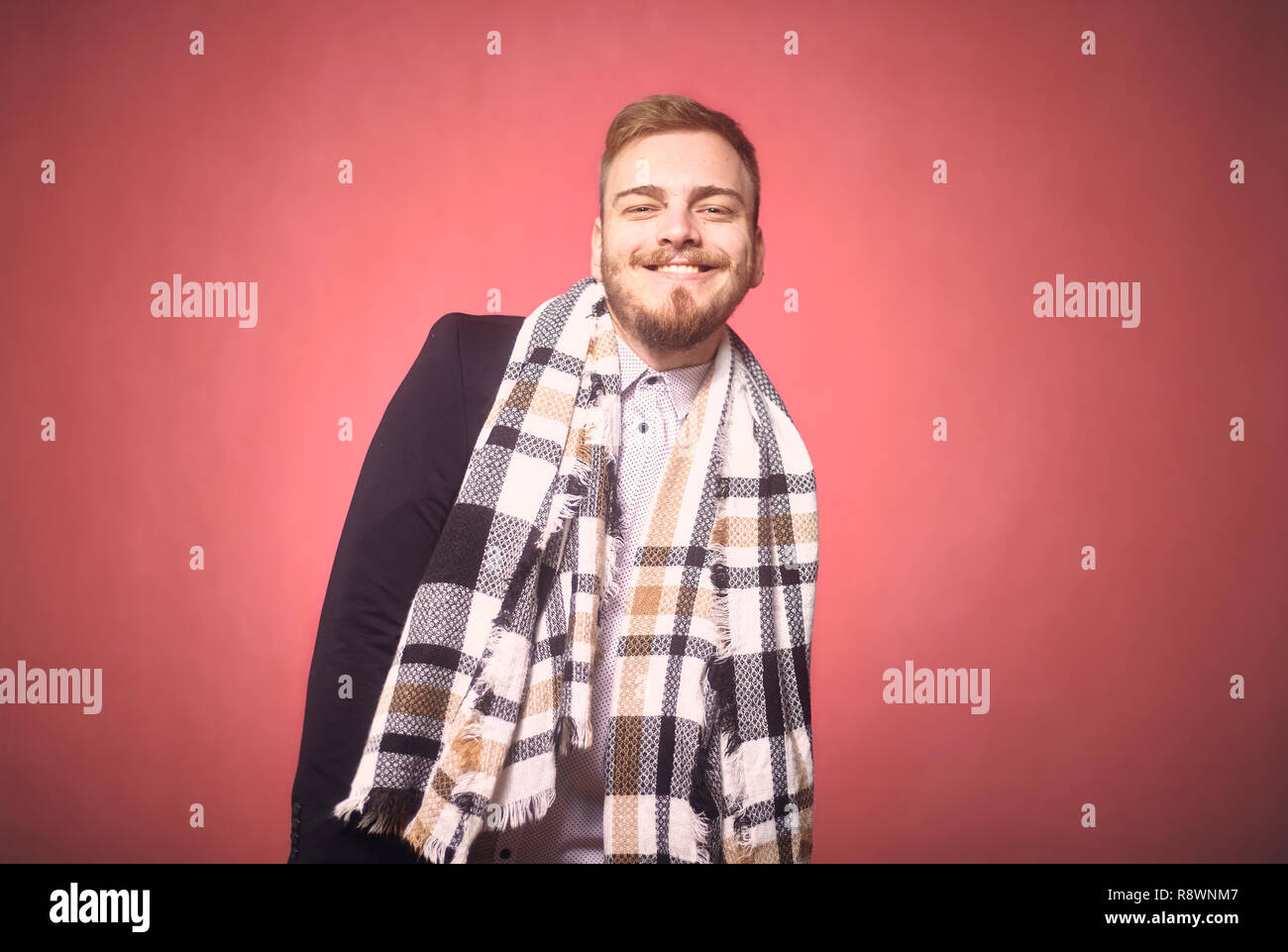 Un giovane uomo, 20-29 anni, sincera espressione sorridente, cercando cordiale e alla fotocamera. sfondo rosa, studio shot, Photo Shoot. Foto Stock