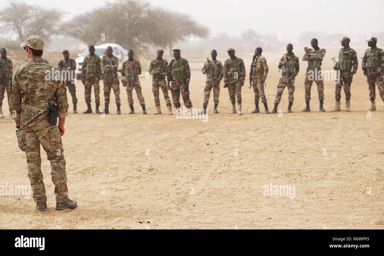 Un U.S. Esercito forze speciali armi sergente parla di un gruppo di soldati Nigerien prima dell'inizio di un compagno di squadra di classe di movimento durante l'esercizio Flintlock 2017 in Diffa, Niger, Marzo 11, 2017. Flintlock 2017 è progettato per potenziare la capacità delle principali nazioni partner nella regione per proteggere le loro frontiere e di garantire la sicurezza per il loro popolo. Foto Stock