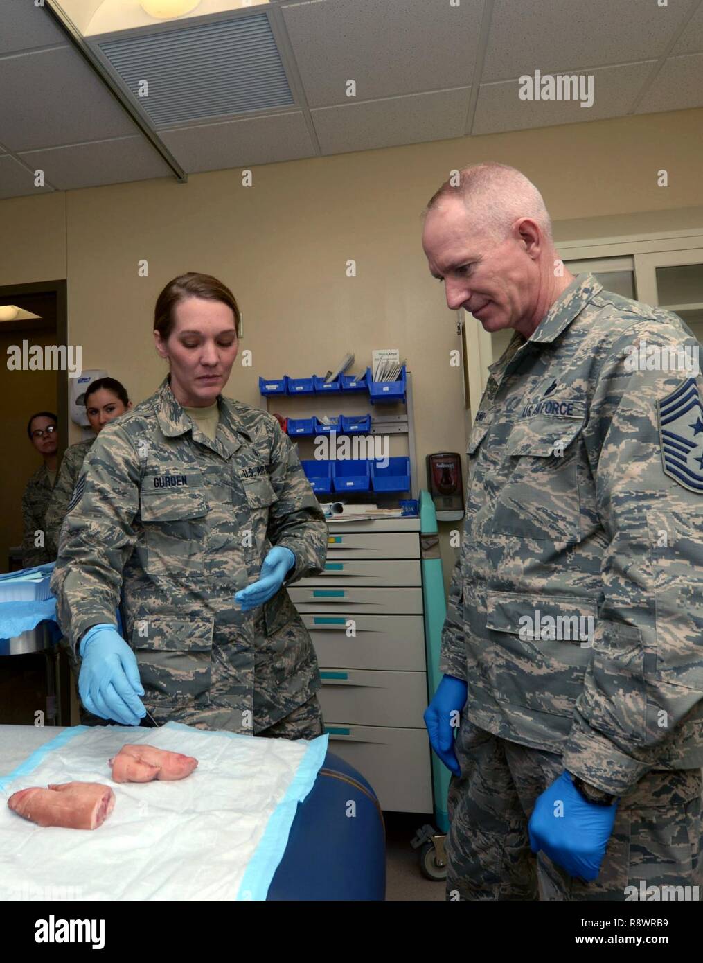 Tech. Sgt. Ashley Gurden, un medico aerospaziale tecnico assegnato alla XXVIII operazioni mediche Squadron, esegue una sutura dimostrativo su un piede di suini con Master Chief Sgt. Alan Boling, capo del comando per l'ottava Air Force, durante una visita a Ellsworth Air Force Base, S.D., 8 marzo 2017. Durante la sua visita, Boling ha anche visitato il raider Café, 28 disponibilità logistica squadrone Centro di distribuzione, orgoglio Hangar e altro ancora. Foto Stock