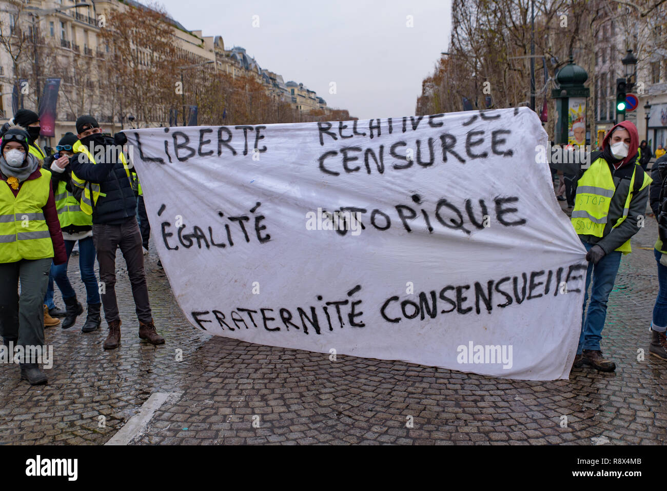 5 giubbotti di giallo di dimostrazione (Gilets Jaunes) manifestanti contro le tasse sul carburante, il governo e il presidente francese Macron con slogan Champs-Élysées Foto Stock