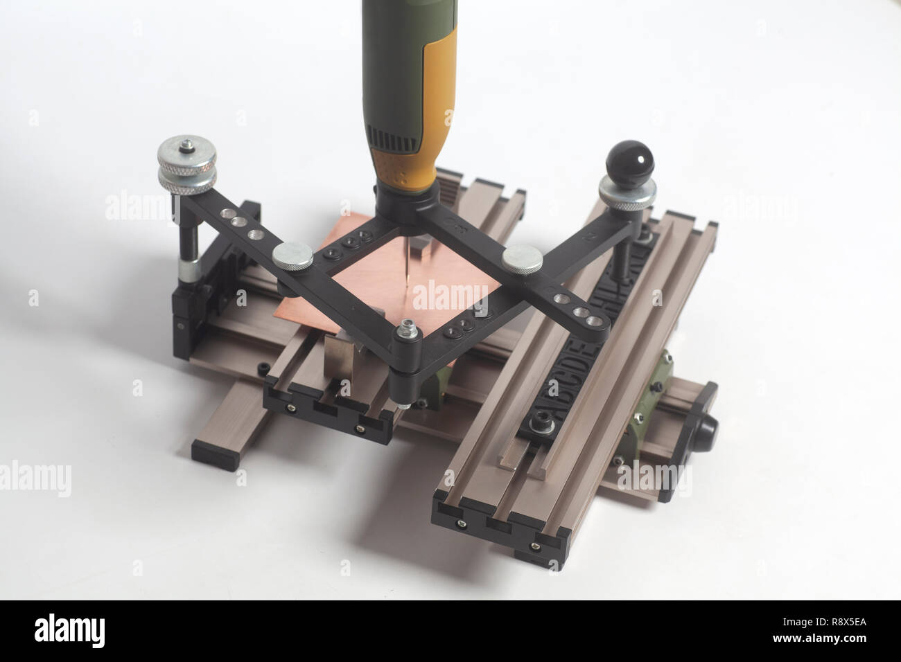 Dispositivo di incisione con pantografo a CNC con incisore alfabeto di stampa in rilievo su uno sfondo bianco Foto Stock