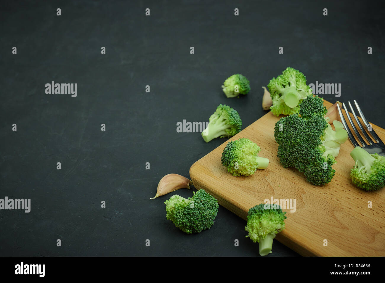 Placer broccoli verdi segmenti da un piccolo cucchiaio. Mangiare sano pattern su sfondo scuro. Spazio Copia vista dall'alto. Cibo vegetariano. Foto Stock