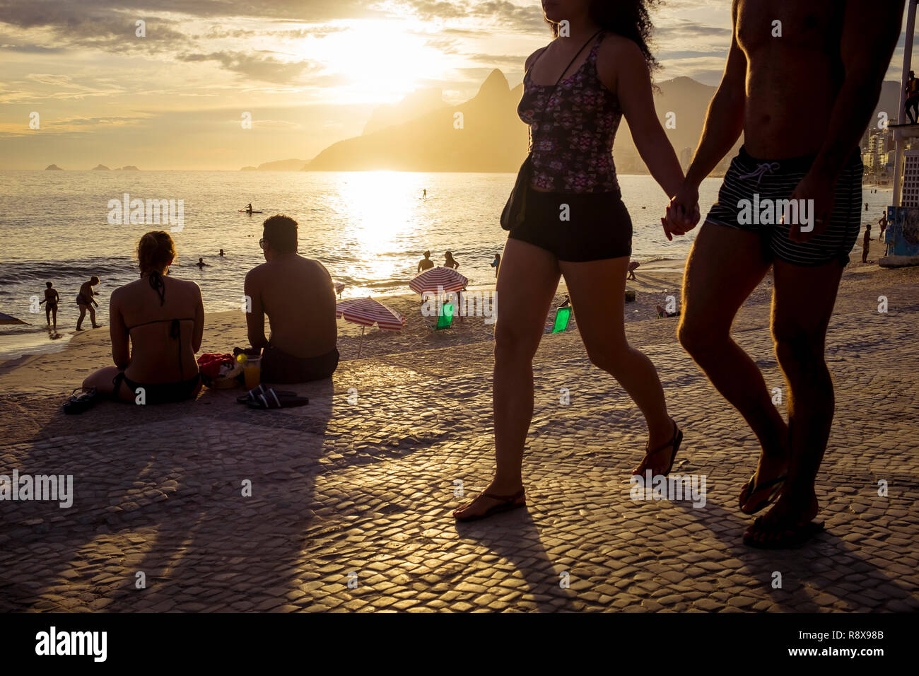 Tramonto panoramico vista silhouette di persone che passeggiano sulla spiaggia di Ipanema promenade di Arpoador a Rio de Janeiro in Brasile Foto Stock