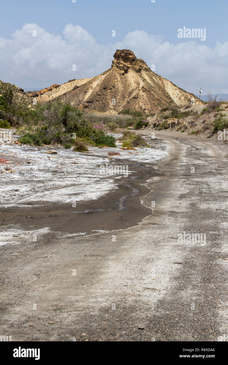 Sporco della pista nel deserto con la montagna in background, Taberna deserto, provincia di Almeria, Andalusia, Spagna Foto Stock