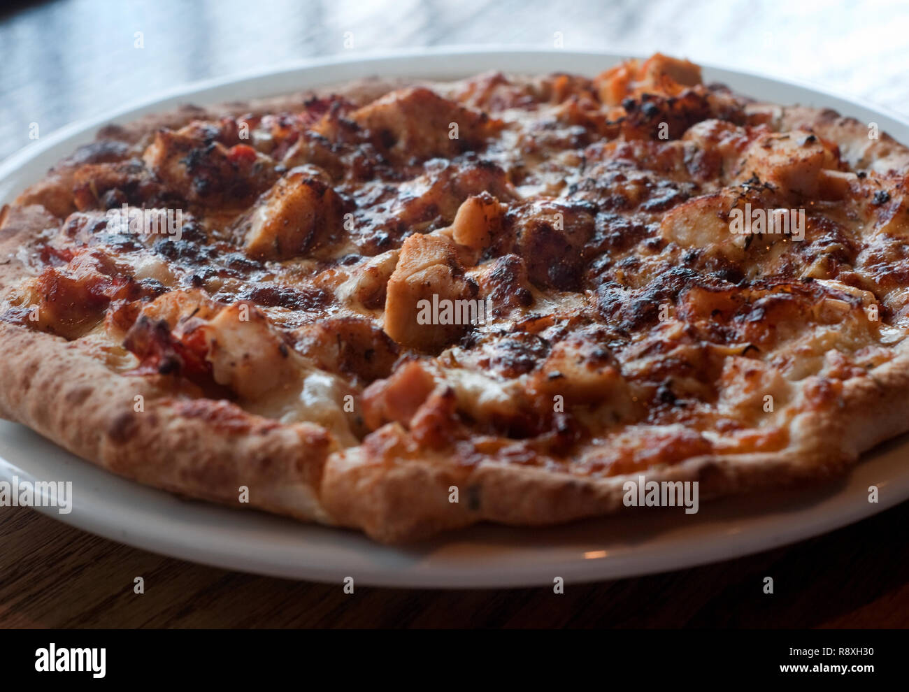 Un pollo alla griglia pizza con pomodori secchi, mozzarella, Jamaican jerk stagionatura e marinara è servita a Soulshine Pizza a Oxford, Mississippi. Foto Stock