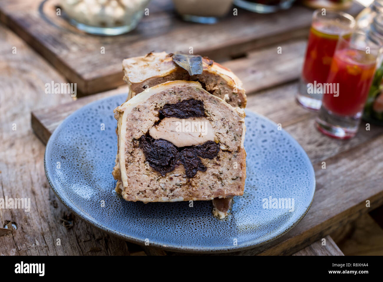 La carne di maiale e di potare terrina sulla piastra blu su pallet di legno a picnic Foto Stock