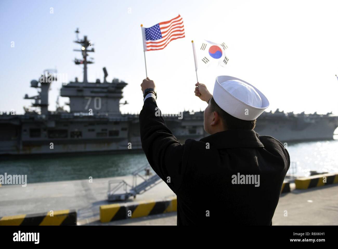 BUSAN, Repubblica di Corea (15 marzo 2017) una repubblica di Corea (ROK) onde marinaio flag come Nimitz-class portaerei USS Carl Vinson (CVN-70) tira nella Rok la sede della flotta. La Carl Vinson Carrier Strike gruppo è su un regolarmente programmati Pacifico occidentale la distribuzione come parte degli Stati Uniti Flotta del pacifico-led iniziativa di estendere il comando e le funzioni di controllo di Stati Uniti 3a flotta. Foto Stock