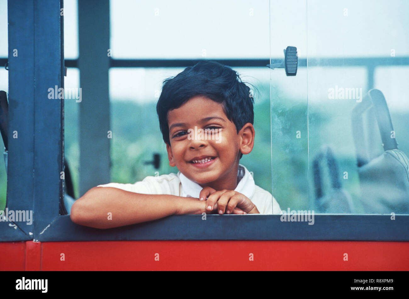 Bambino guardando fuori della finestra del bus Foto Stock