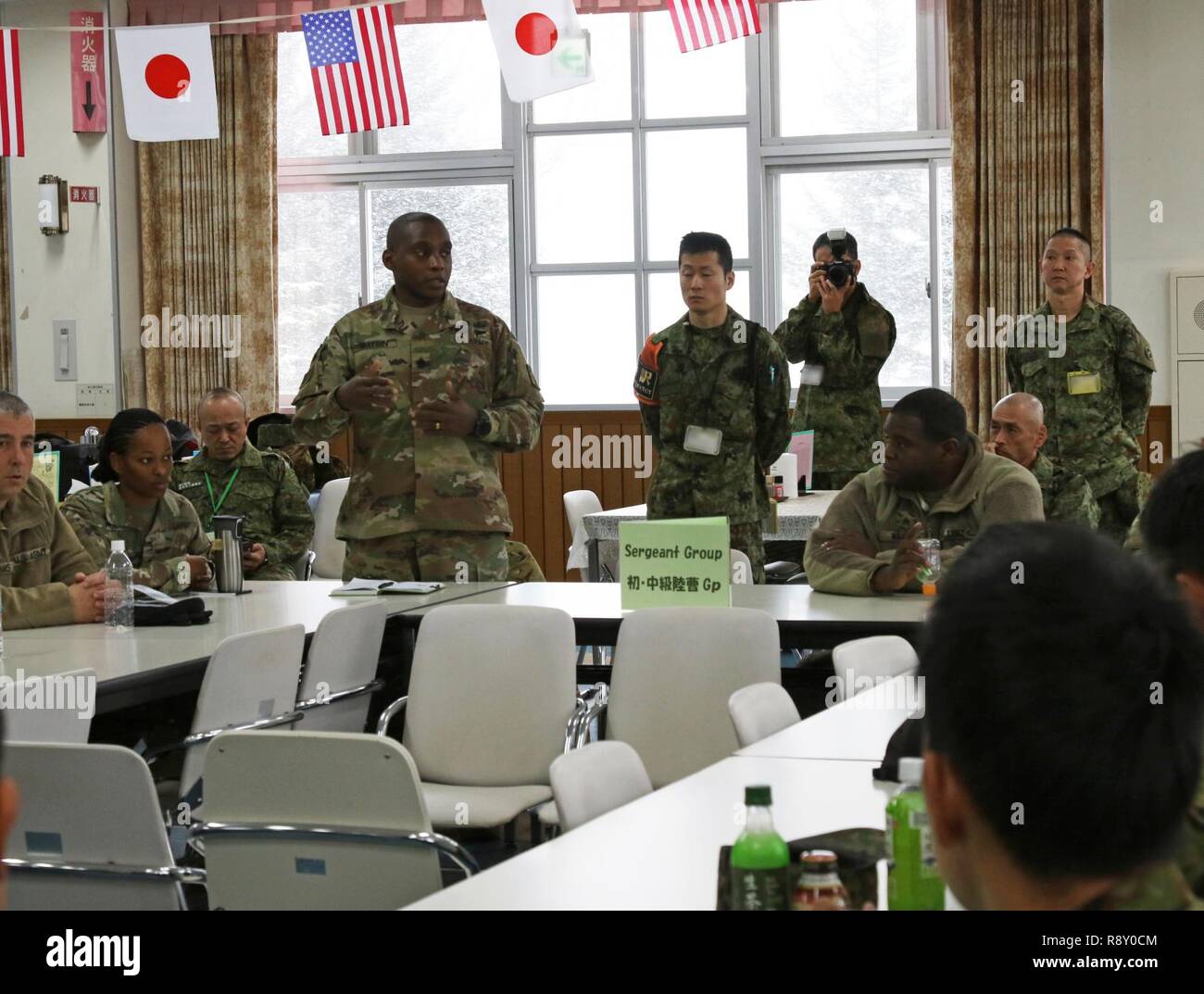 Stati Uniti Esercito e Giappone terra Forza di Autodifesa noncommissioned officers discutere le somiglianze e le differenze tra i due eserciti in uno scambio culturale prima del calcio di inizio di Yama Sakura 75 a Camp Higashi Chitose, Giappone, Dicembre 6, 2018. Yama Sakura è un accordo bilaterale per il posto di comando esercizio con il Giappone terra Forza di Autodifesa in cui Stati Uniti e le forze giapponesi scambiare idee, tecniche, esperienza militare e di esercitare le funzioni in difesa del Giappone. L'esercizio evidenzia la forza della stretta e lunga relazione gli Stati Uniti con il Giappone e il JGSDF. Stati Uniti Esercito Foto Stock