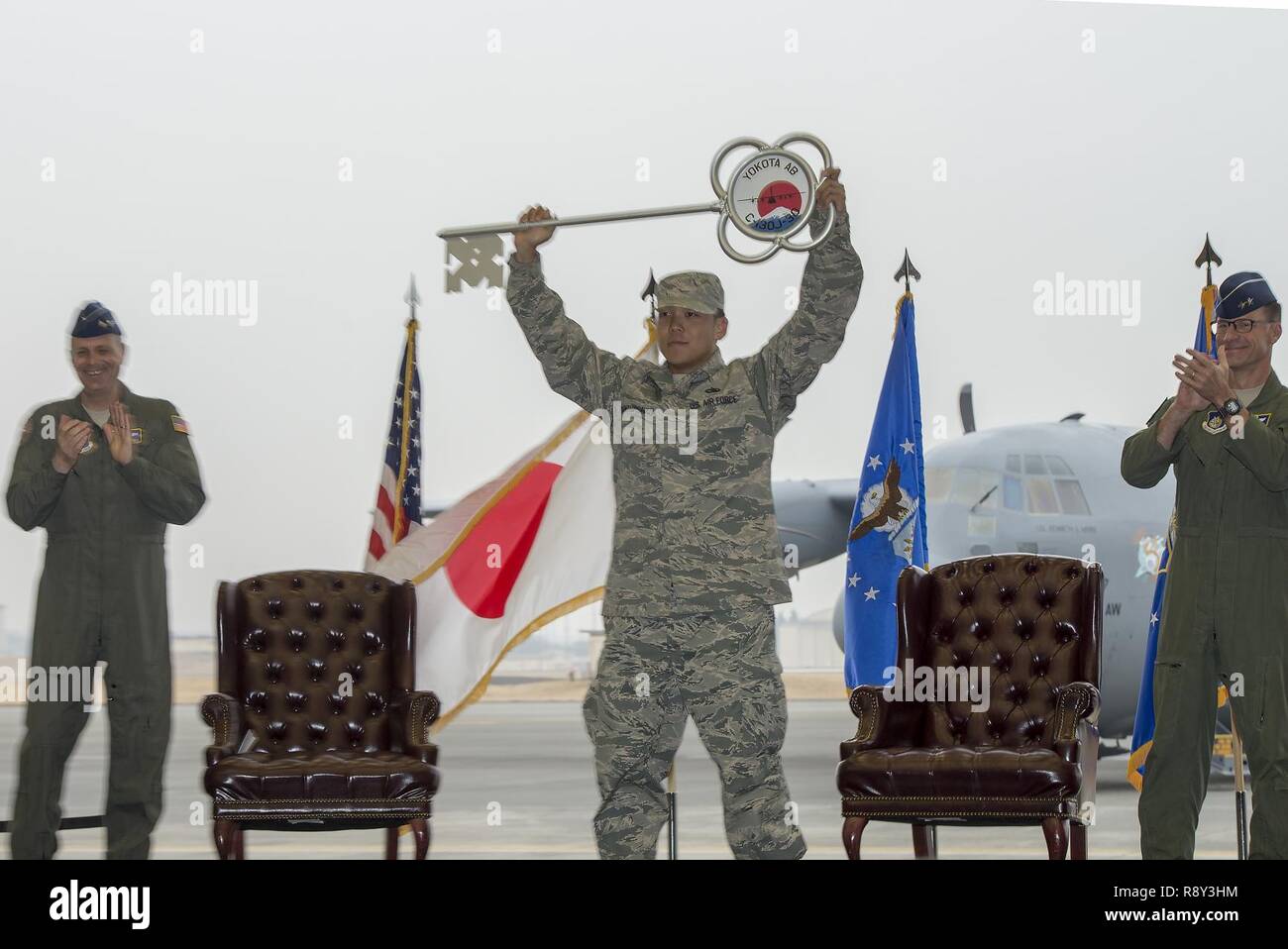 Il personale Sgt. Gene Phonthipsavath, 374 Manutenzione aeromobili squadrone dedicato capo equipaggio, detiene aloft il cerimoniale di tasto durante una cerimonia di premiazione che si terrà a festeggiare l'arrivo del primo C-130J Super Hercules assegnato a Yokota Air Base, Giappone, Marzo 6, 2017. Il nuovo aeromobile è programmato per hanno completamente sostituito le 374 Airlift Wing C-130 Hercules flotta entro il 2018. Foto Stock