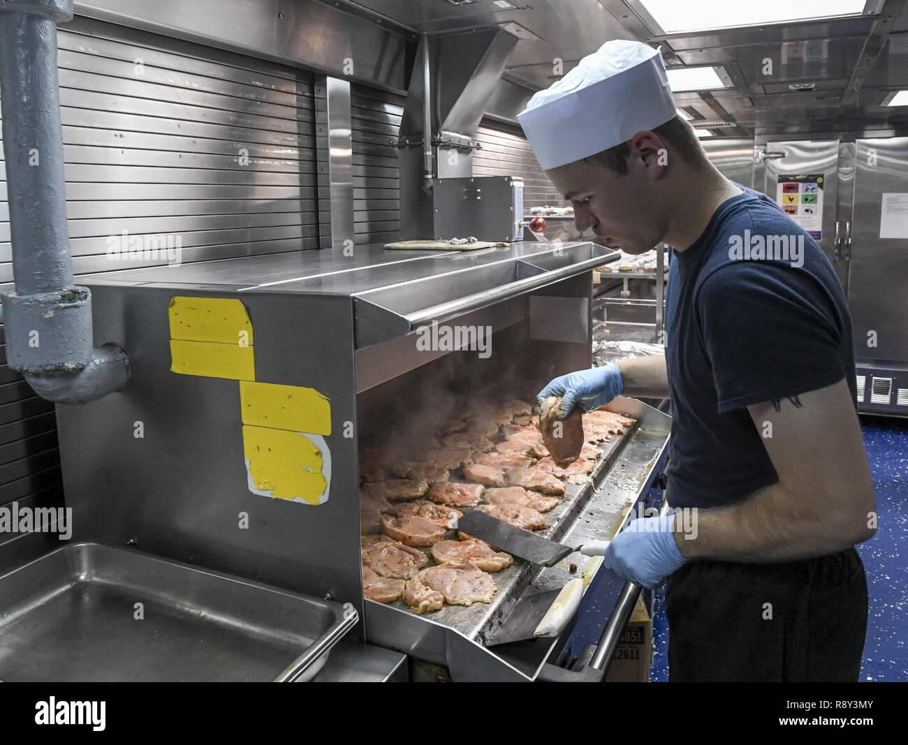 Sul mare del sud della Cina (4 marzo 2017) specialista culinaria di terza classe Crihfield Tyler, da San Diego, grigliate a bordo di pollo Arleigh Burke-class guidato-missile destroyer USS Wayne E. Meyer (DDG 108). Wayne E. Meyer è su un regolarmente programmati Pacifico occidentale di implementazione con la Carl Vinson Carrier Strike gruppo come parte dell'U.S. Flotta del pacifico-led iniziativa di estendere il comando e le funzioni di controllo di Stati Uniti 3a flotta nell'Indo-Asia-regione del Pacifico. Stati Uniti Navy portaerei strike gruppi hanno pattugliato il Indo-Asia-Pacifico regolarmente e sistematicamente per più di 70 anni. Foto Stock