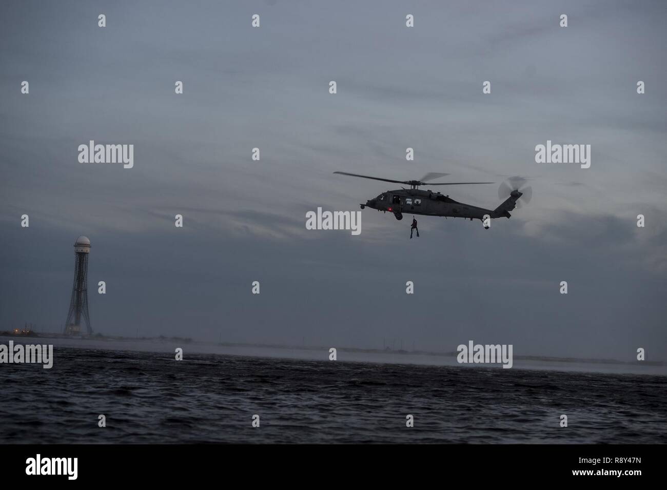 Un U.S. Air Force pararescueman assegnato al ventitreesimo Tattiche speciali squadrone è issato in un U.S. Navy MH-60S Seahawk durante il guerriero di smeraldo 17 al campo Hurlburt Fla., Marzo 4, 2017. Il Guerriero di smeraldo è un U.S. Il Comando Operazioni Speciali esercizio durante il quale comune di forze per le operazioni speciali treno per rispondere alle varie minacce in tutto lo spettro di un conflitto. Foto Stock