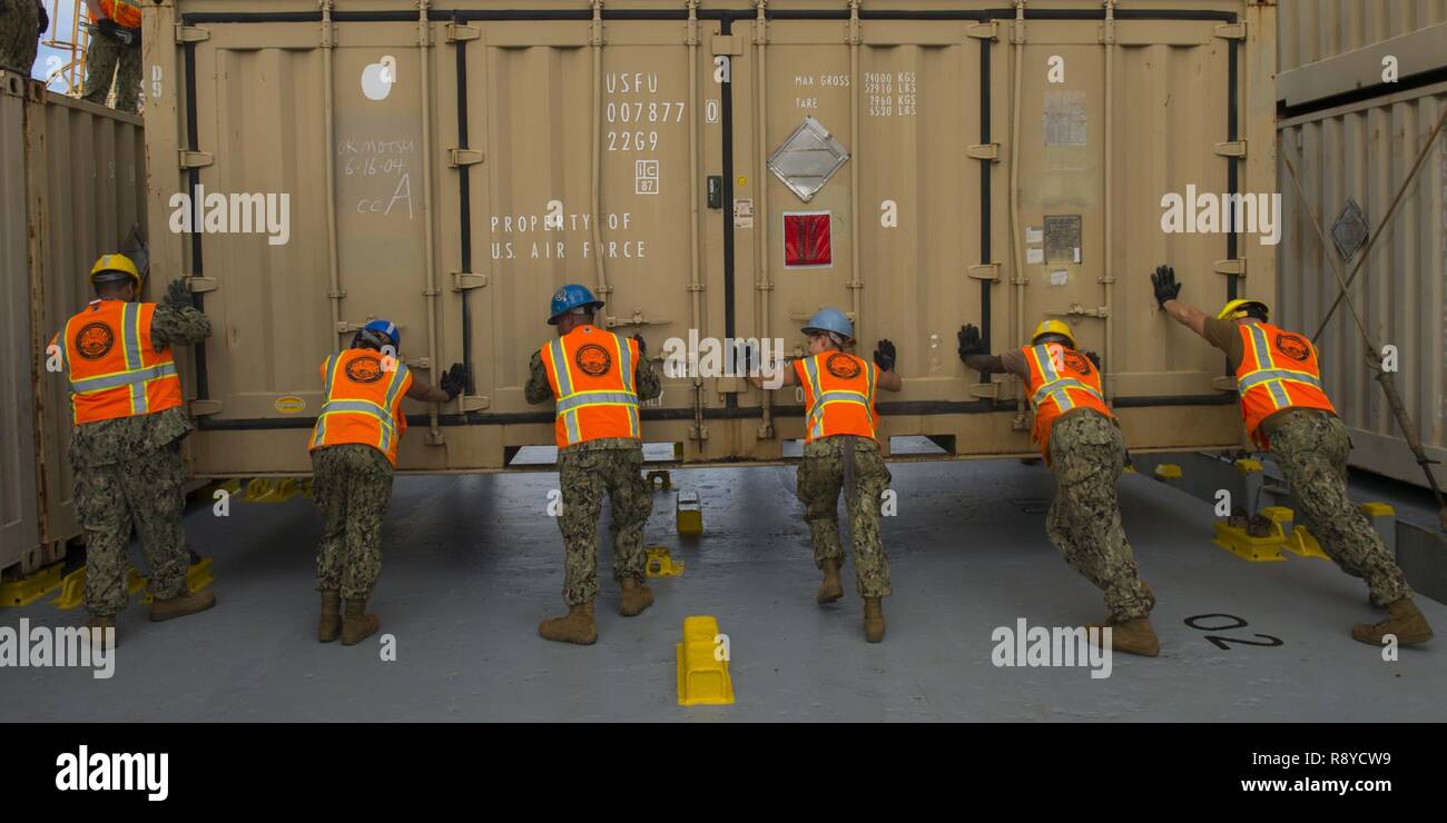 Velisti assegnati a Navy Cargo Handling battaglione 1 (NCHB1) guida un contenitore di munizioni a bordo i militari Sealift nave comando MV principali Bernard F. Fisher (T-AK-4396) presso la base navale di Guam Marzo 8, 2017. NCHB1 è la marina è attivo solo dovere di movimentazione dei carichi e il battaglione è un rapidamente dispiegabile unità operativa della Marina Expeditionary comando di combattimento in grado di carico e scarico di navi e di aeromobili in tutte le condizioni climatiche e di condizioni di pericolo. Foto Stock