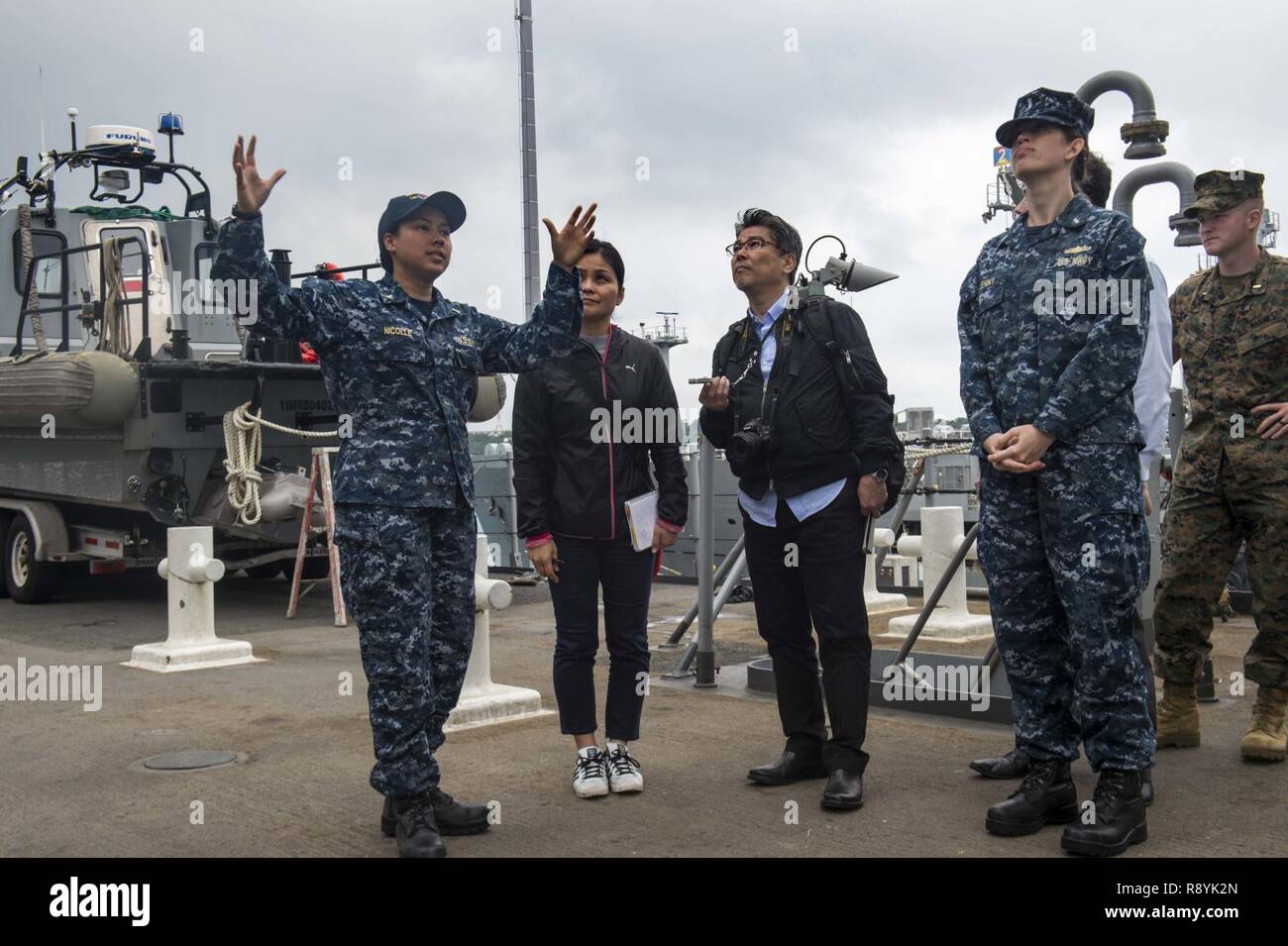 OKINAWA, in Giappone (17 marzo 2017) Ensign Vanessa Nicolle parla di Sunao Gushiken, un reporter per Giapponese quotidiano nazionale La Asahi Shimbun, durante un media tour a bordo del dock anfibio sbarco nave USS Ashland (LSD 48). Ashland, parte dell'Bonhomme Richard Expeditionary Strike gruppo, con avviato 31 Marine Expeditionary Unit, è su una pattuglia di routine, operando in Indo-Asia-regione del Pacifico per rafforzare le partnership e di essere una pronta risposta in vigore per qualsiasi tipo di emergenza. Foto Stock