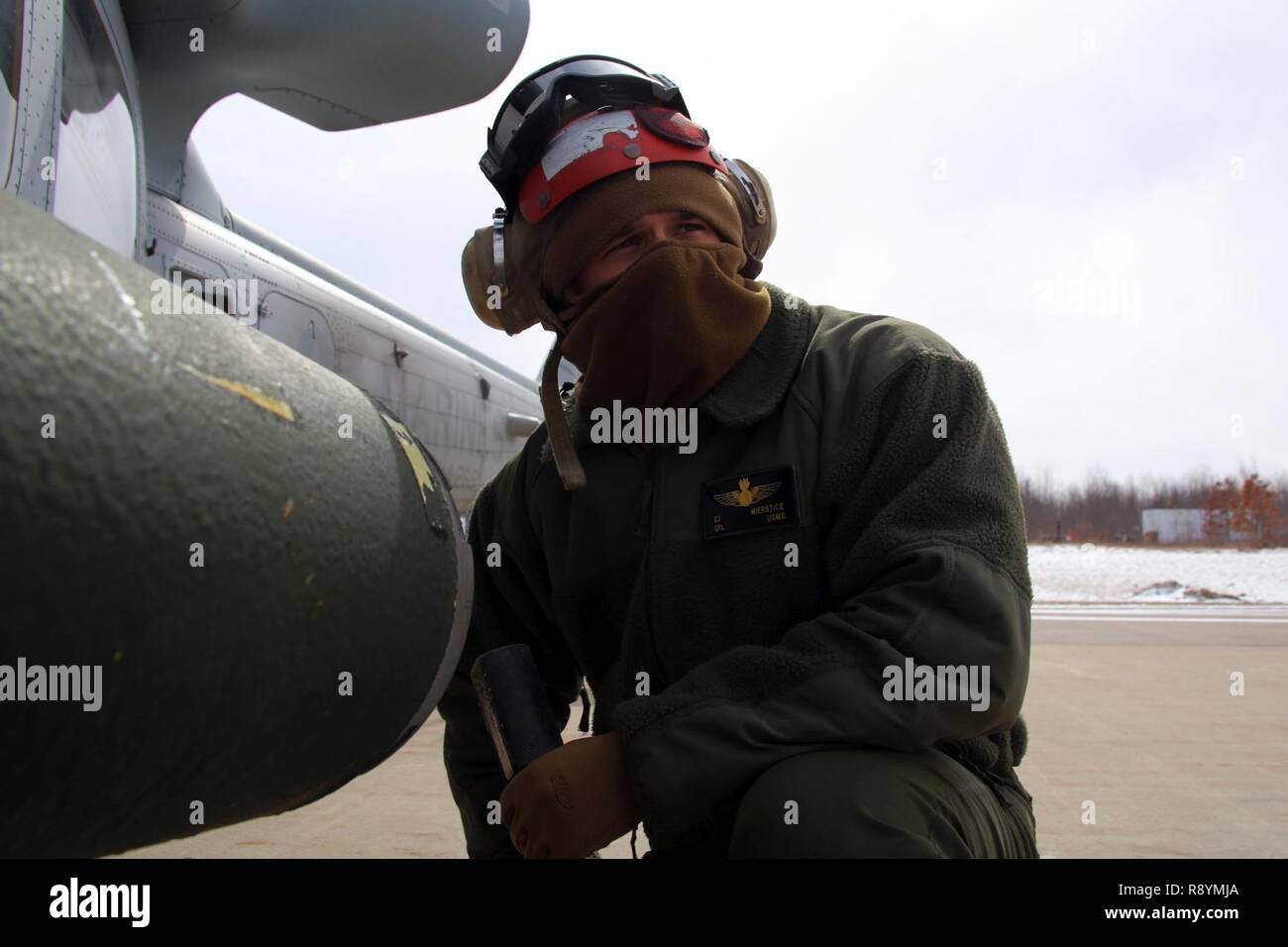 Cpl. Cadei Mierstice supervisiona il suo Marines come essi velivoli di carico per basse temperature le operazioni di volo a bordo di Ft. Tamburo, N.Y., Marzo 11, 2017. Mierstice afferma che egli cerca di condurre il suo Marines da esempio e non lasciate mai loro di fare qualcosa che non vuole fare. "Murphey's legge è una specie di grande cosa qui", ha detto Mierstice. "Tutto ciò che può andare storto andrà storto. Dobbiamo solo per superare gli ostacoli e siamo sempre riusciti a squadra.' Mierstice è un aviation ordnance tecnico con Marine Attacco leggero elicottero Squadron 269. Foto Stock