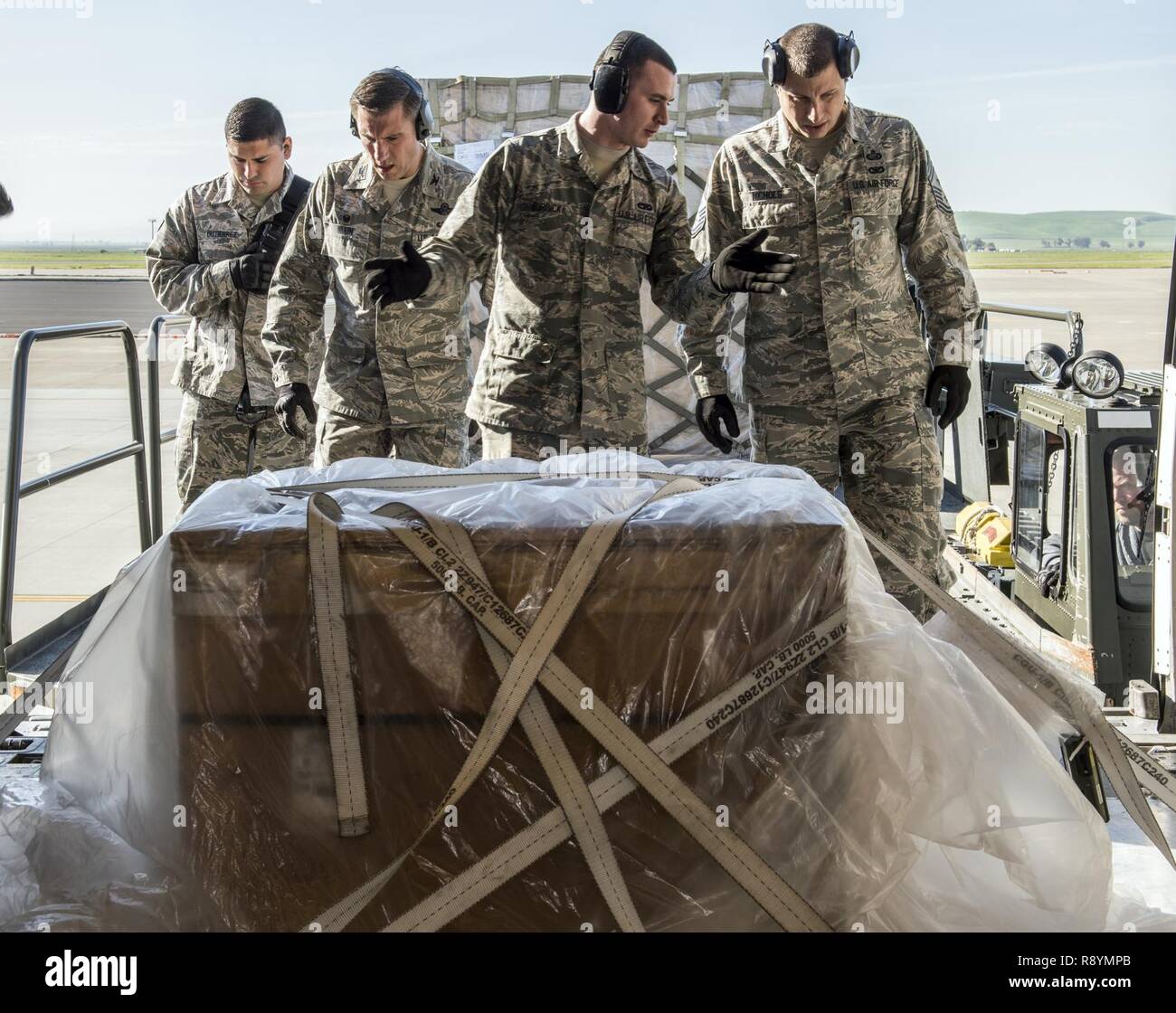 (Da sinistra a destra) U.S. Air Force Senior Airman Allen Gutierrez , sessantesimo porta antenna Squadron , Col. John Klein, sessantesimo di mobilità in aria Wing Commander, Airman 1. Classe Mark Burdick, 60 APS, e Chief Master Sgt Steven Nichols, 60 AMW command chief unito gli sforzi per condurre una funzione rampa servizio a Travis Air Force Base in California, Marzo 17, 2017 come parte delle opere con gli avieri Programma. Burdick ha spiegato il processo di trasferimento di carichi palettizzati da un 60k Tunner loader su un KC-10 Extender aeromobili. Il funziona con gli avieri programma è progettato per consentire l'ala leadership le opportunità di ombra juni Foto Stock