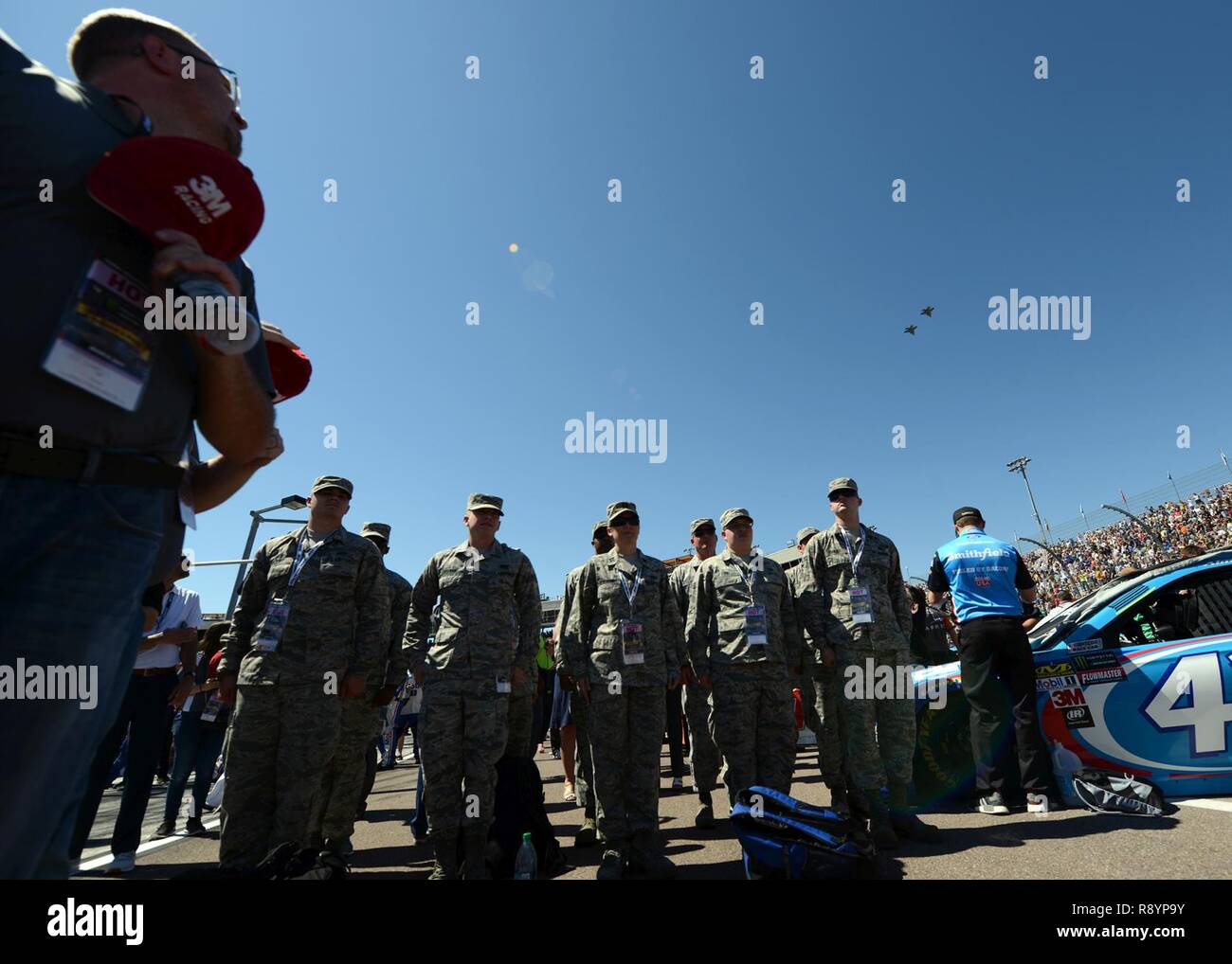 Aviatori di Luke Air Force Base si erge a attenzione mentre due F-35s dalla sessantaduesima Fighter Squadron esegue un cavalcavia durante la cerimonia di apertura del campeggio mondo 500 Mar 19, 2017 al Phoenix International Raceway, Ariz. Foto Stock