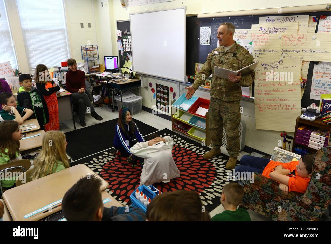 Sgt. 1st. Classe Edward Swiger, un 20-anno veterano per il ventesimo chimici, biologici, radiologici, nucleari esplosivi e comando, legge per una classe di 4th-graders da uno dei suoi libri preferiti, il 'FM 7-22' conosciuto anche come "l'esercito fisico manuale di formazione " come fare una corretta sit-up durante la lettura della celebrità giorno a Churchville scuola elementare sul Mar. 17. L evento è stato parte della scuola del mese di lettura di feste. Foto Stock