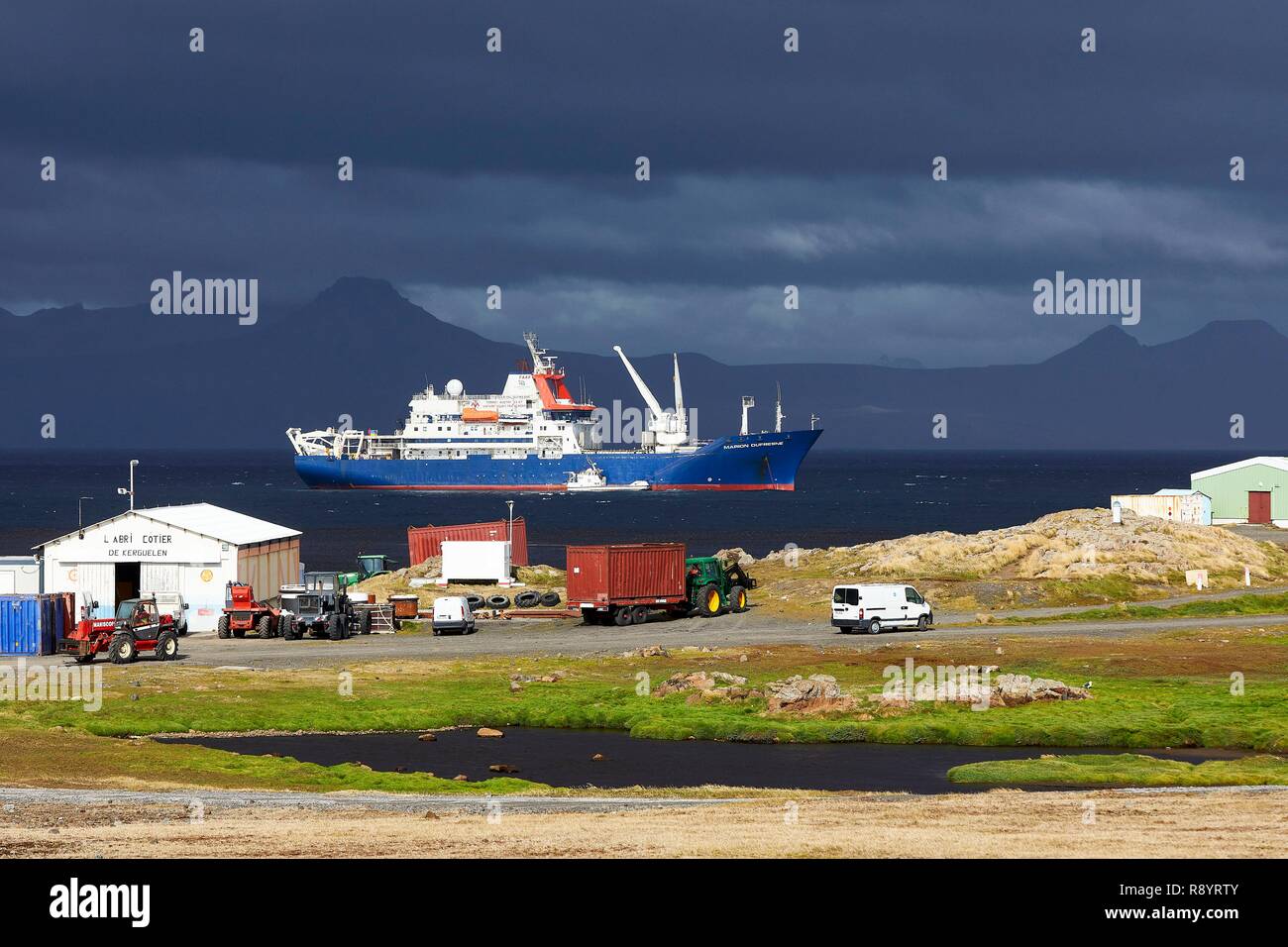 Francia, Oceano Indiano, Terre australi e antartiche francesi, Marion Dufresne (alimentazione e nave oceanografica del TAAF), Isole Kerguelen, la nave ancorata a Port-aux-Français con la penisola di Ronarc'h in background Foto Stock