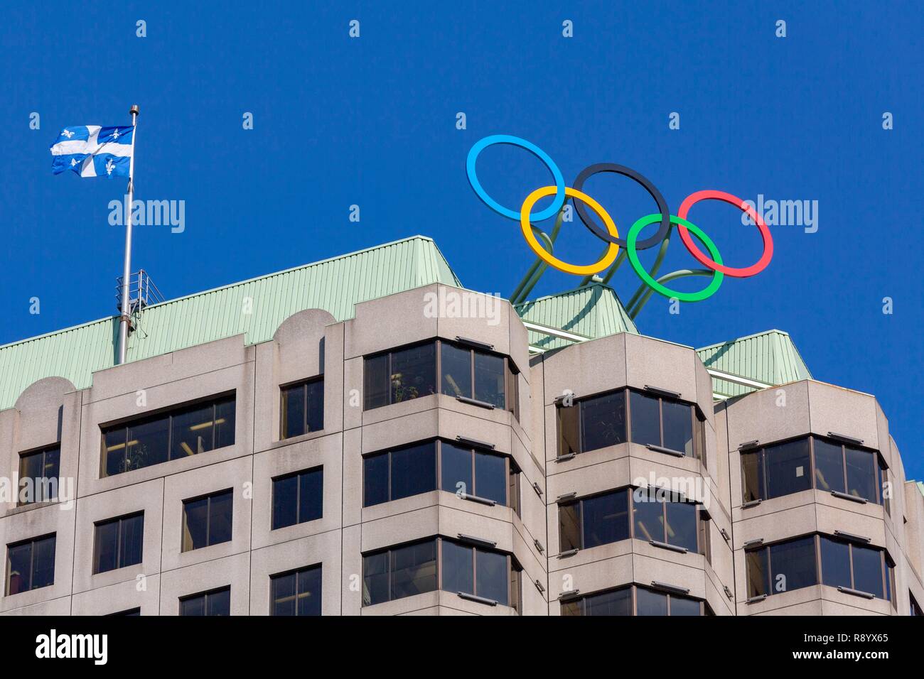 Canada, Provincia di Quebec, Montreal Downtown, Canada Olympic House (CIO), anelli olimpici e bandiera del Quebec Foto Stock