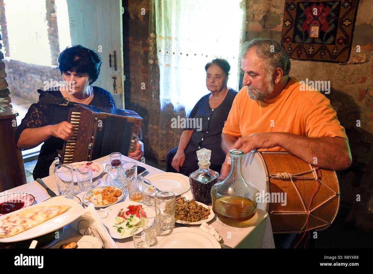 La Georgia, Kakheti, Akhmeta, tradizionale pasto di festa in una famiglia Tusheti, canzoni accompagnate da fisarmonica e tamburo Foto Stock